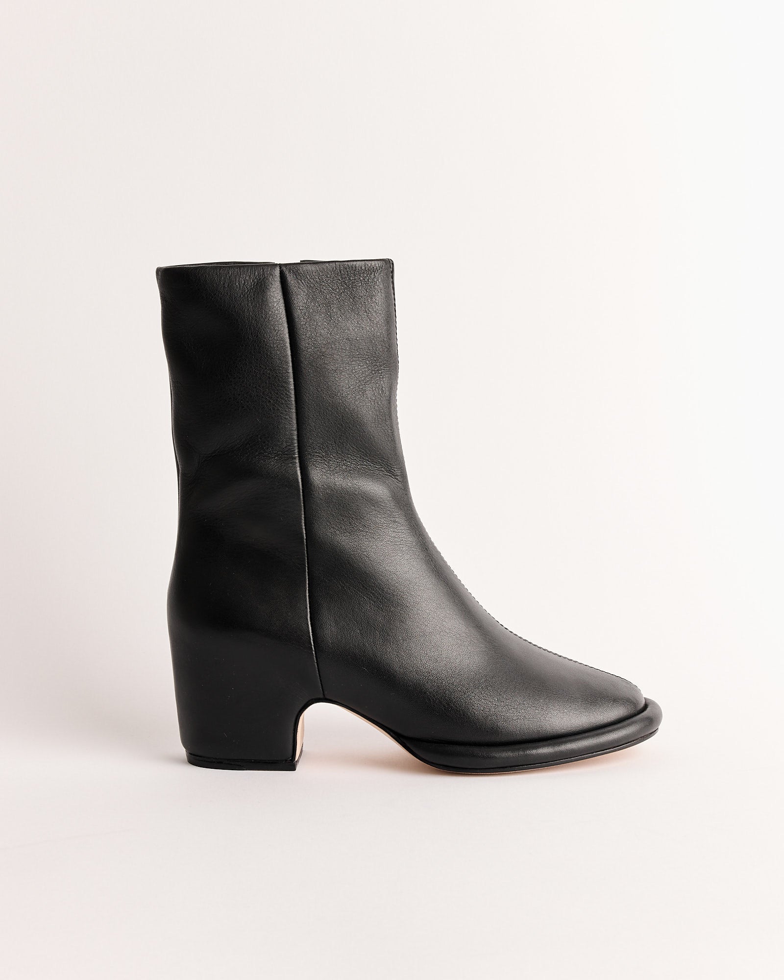 The Lauren Manoogian Arch Boot in Black is a handmade Peruvian leather boot with vegetable-tanned leather, a rounded toe, and chunky mid-height heel, shown against a plain light background.