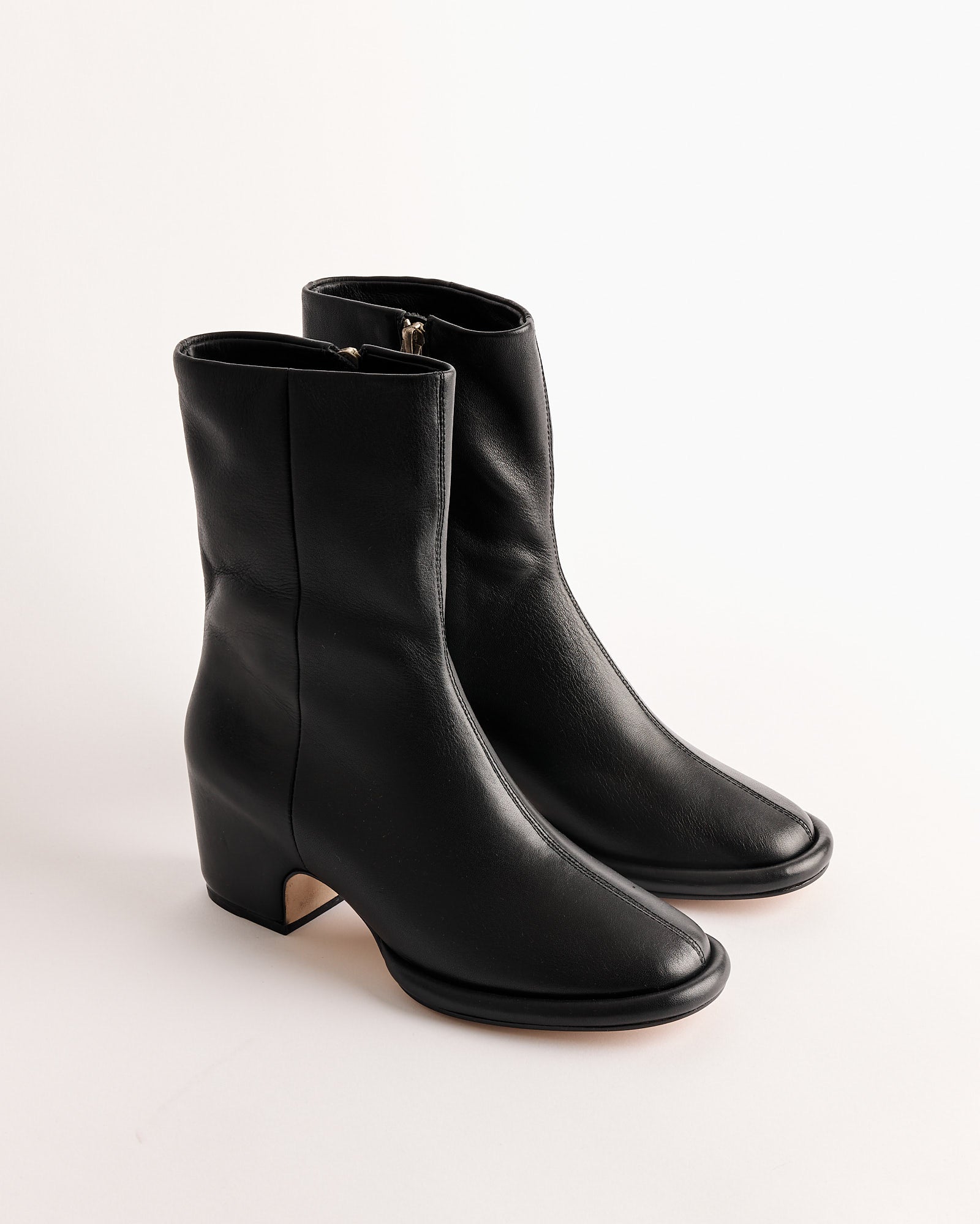 The Arch Boot in Black by Lauren Manoogian is a pair of handmade Peruvian ankle boots in vegetable-tanned leather with side zippers, low block heels, and slightly rounded square toes, shown on a plain white background.
