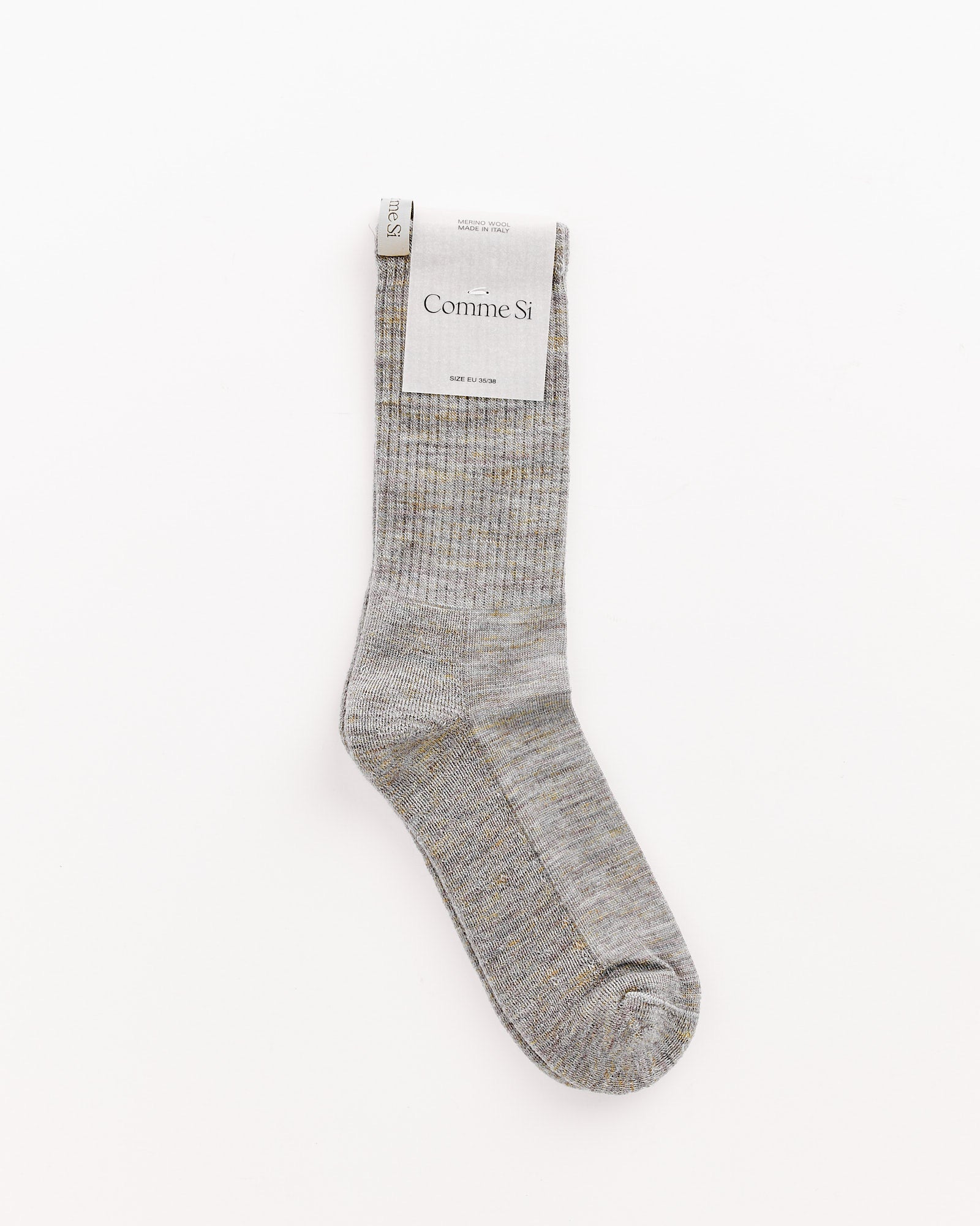A single Rainbow Melange Tube Sock by Comme Si is shown flat on a white background with the brand tag near the cuff. For fit or sizing questions, our online chat is ready to help.