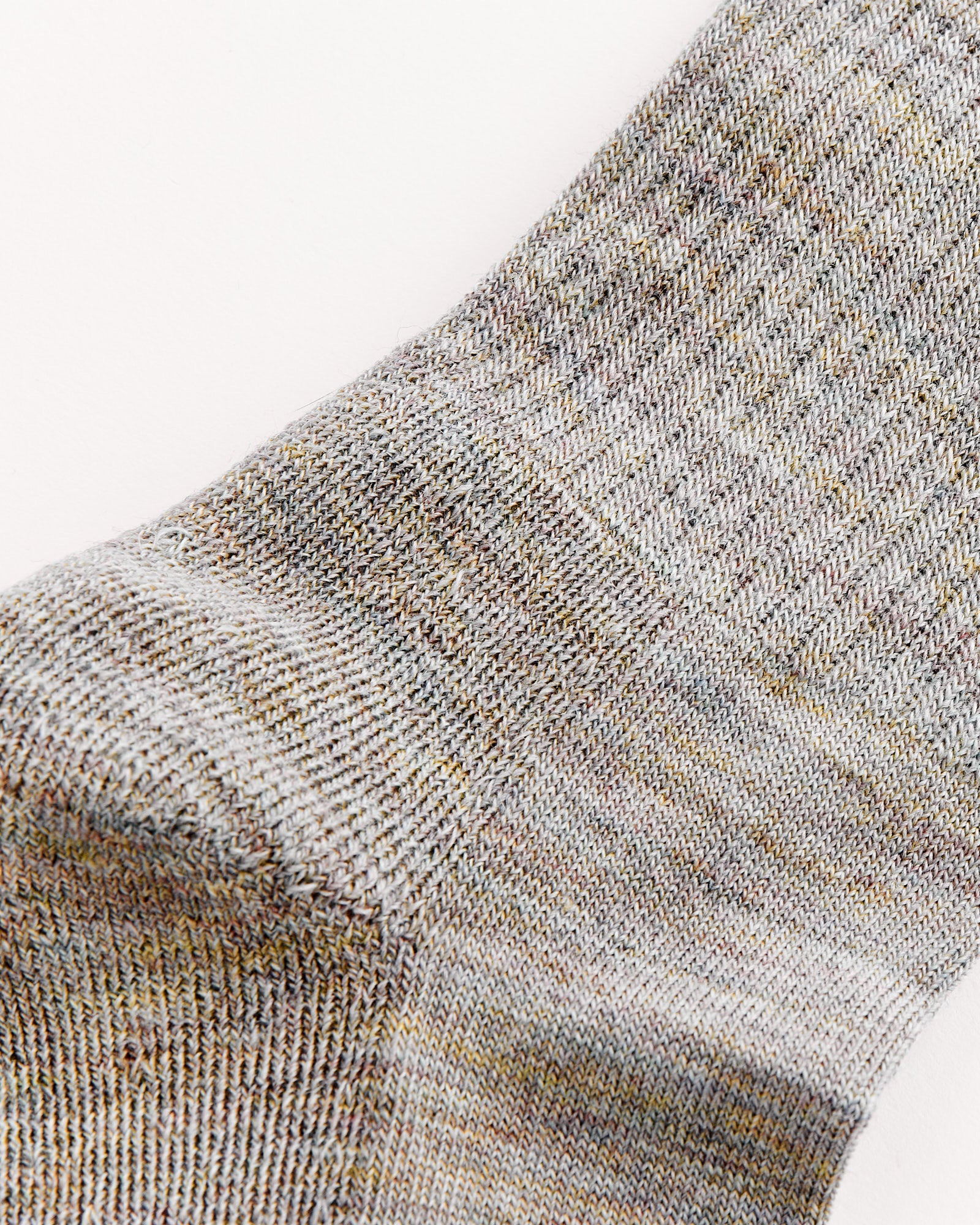 Close-up of The Tube Sock in Rainbow Melange by Comme Si, highlighting its ribbed texture and colorful flecks—ideal for a snug fit or for those with sizing questions via online chat.