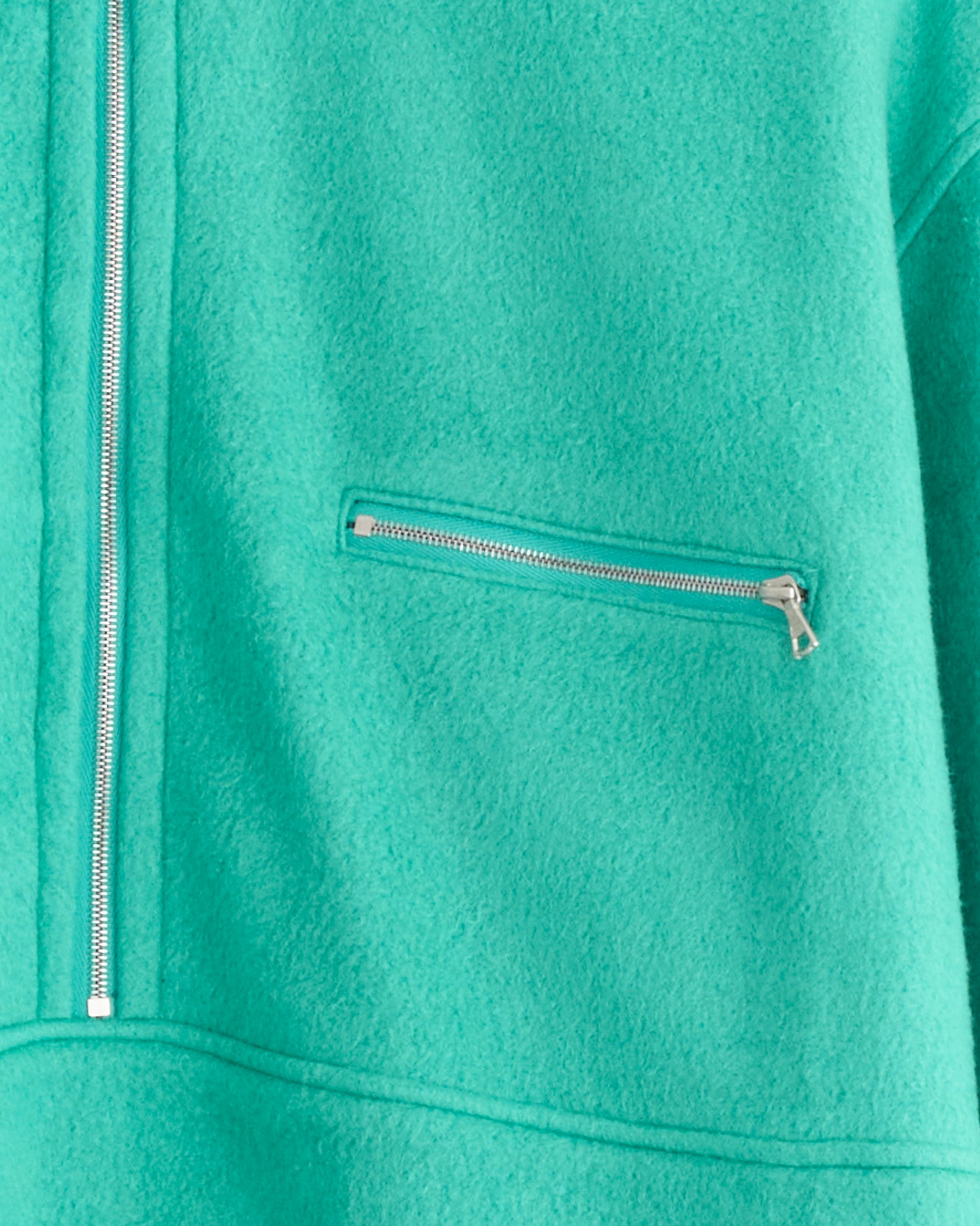 A close-up of the Auralee Pure Silk Half Zip Pullover in Jade Green, made in Japan, featuring a vertical half-zip and a horizontal zippered chest pocket.