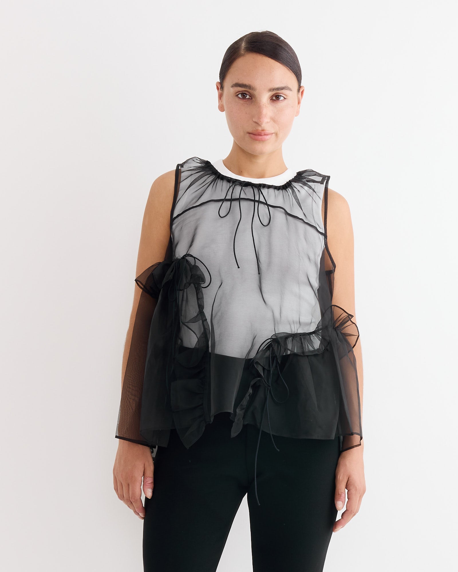 A woman in the Cecilie Bahnsen Orsalina Top in Black, a striking silk organza blouse.