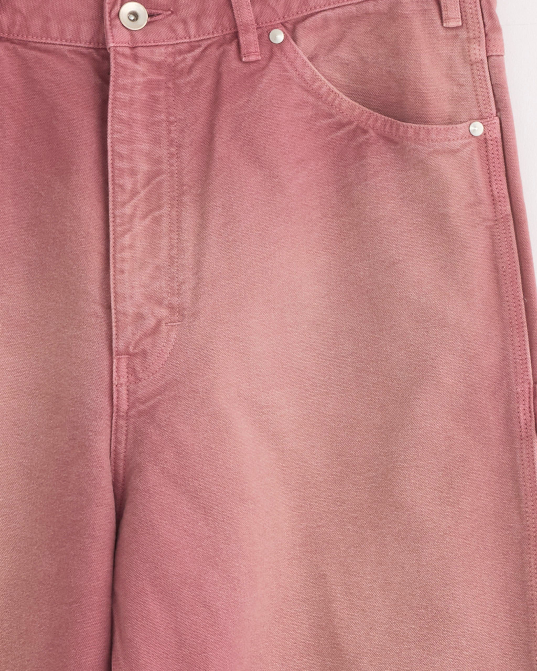 Close-up of Auralee's Dyed Duck Painter Pant in Faded in Burgundy, featuring organic cotton duck fabric with a garment-dyed finish for a soft texture and subtle faded look, highlighting the waistband, front pocket, and closure details.