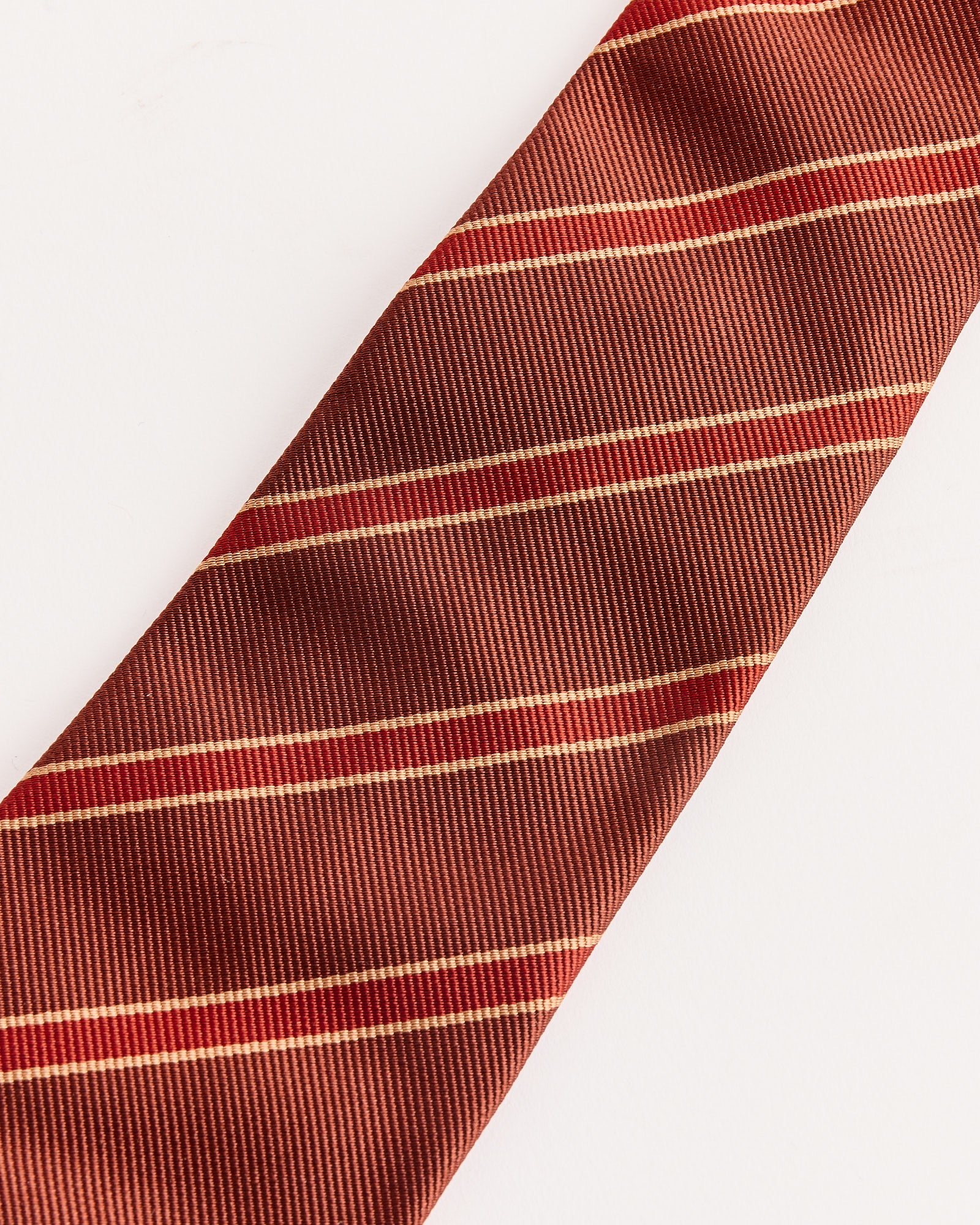 A close-up of the Auralee Silk Stripe Tie in Burgundy, crafted from 100% silk twill in Japan.