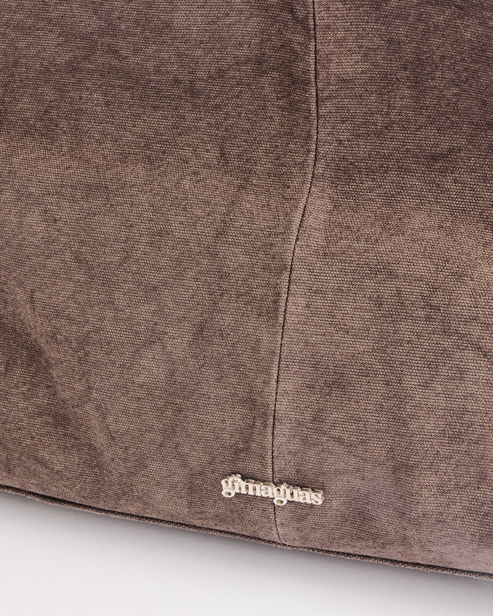 Close-up of the Annamaria Canvas Bag by Gimaguas, showing its brown suede-like texture, prominent center stitching, and the brand name delicately embroidered near the bottom.