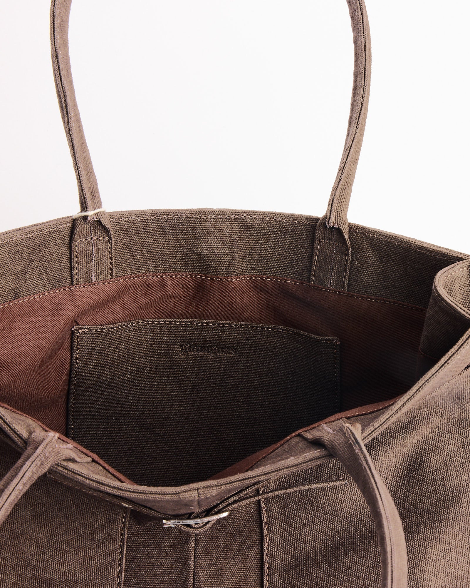 Close-up of the interior of the Annamaria Canvas Bag by Gimaguas, featuring sturdy handles, a stitched inner pocket, and thick brown canvas fabric that showcases the quality craftsmanship typical of Gimaguas bags.