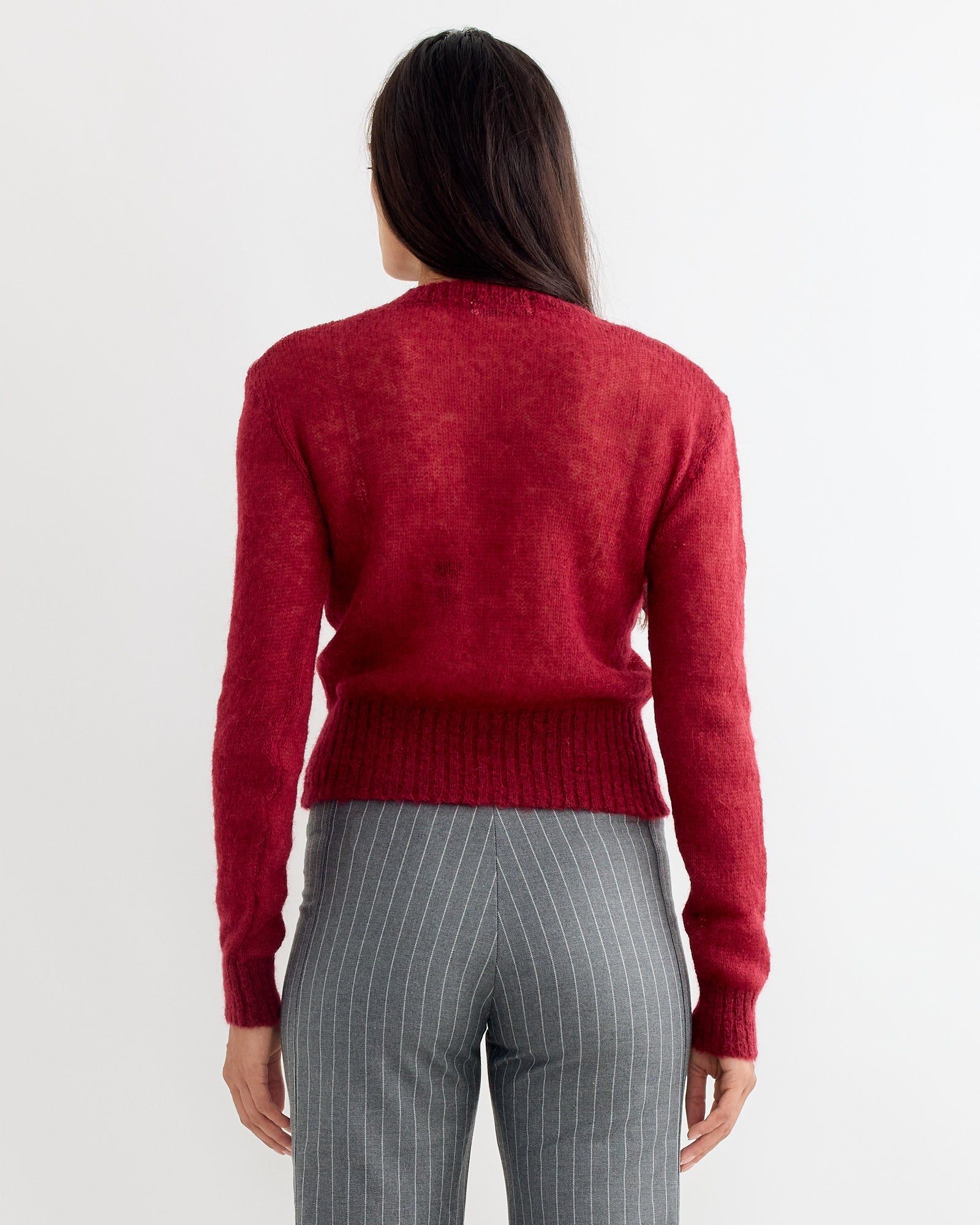 A person with long dark hair, seen from behind, wears the Gimaguas Mum Jumper in Burgundy with gray pinstripe pants against a plain white background.