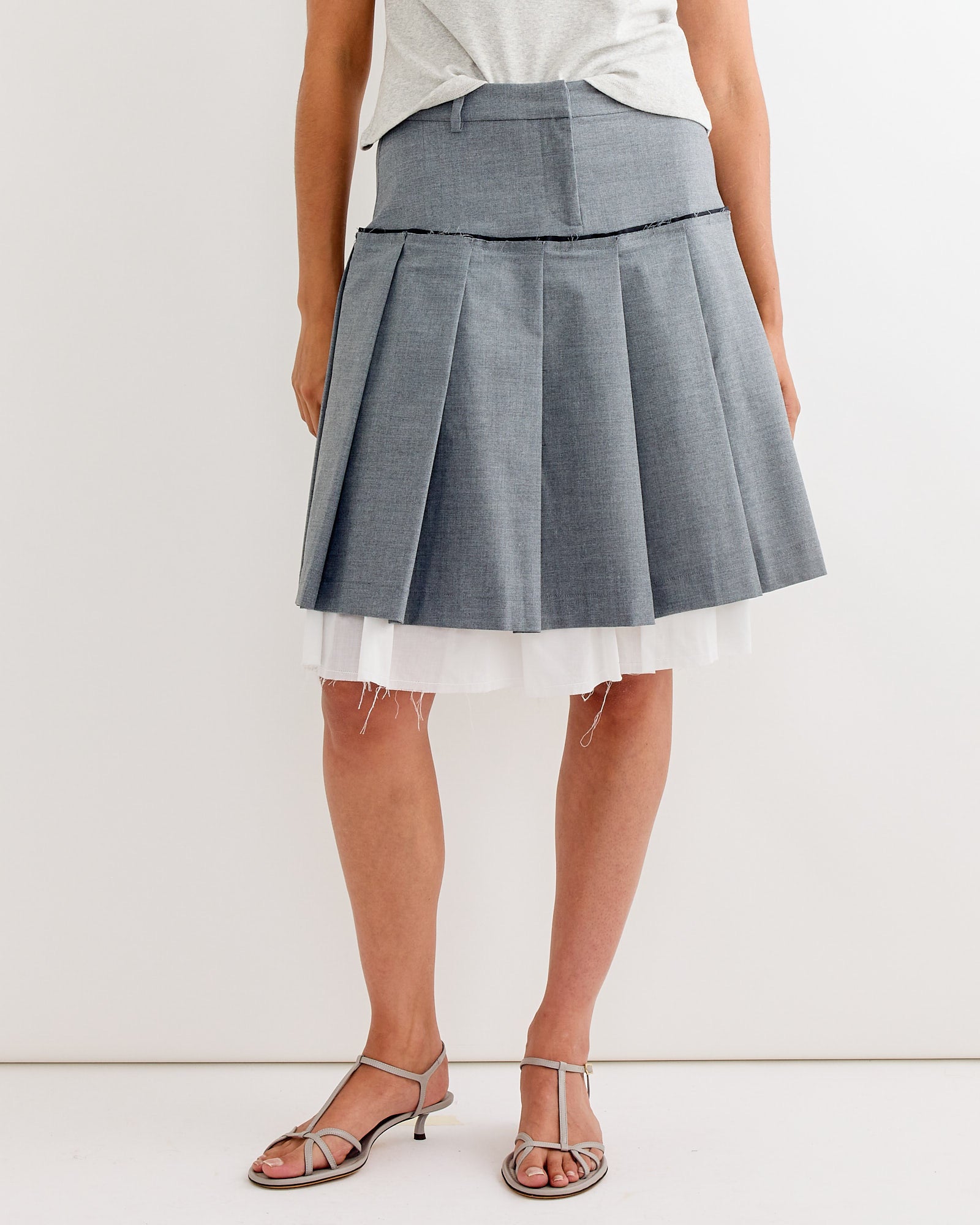 A person wearing the Gimaguas Tailored Midi Skirt in Grey, paired with a matching top and strappy sandals, stands against a plain white background.