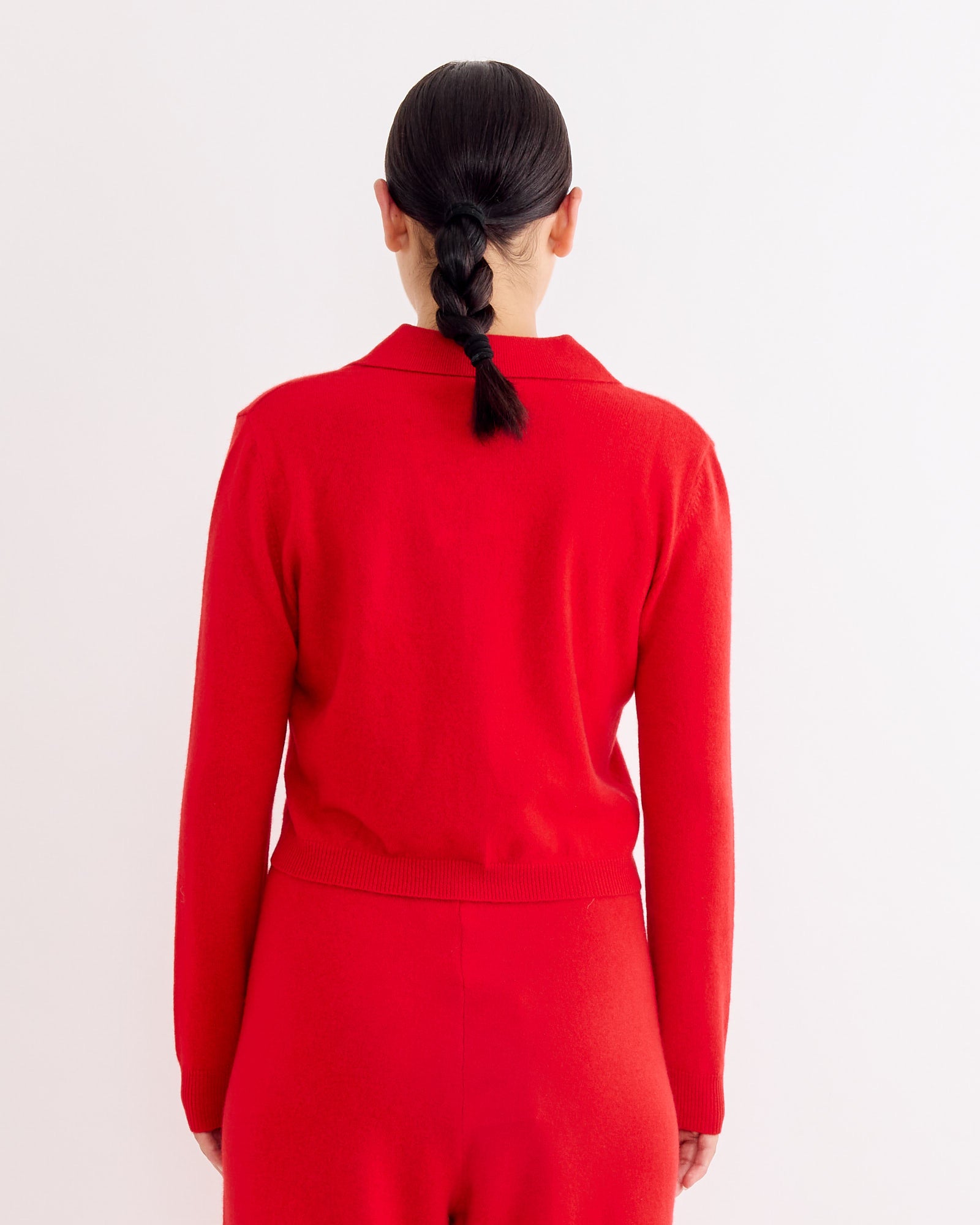A woman in Hai’s Anselma Cardigan in Red, featuring a slim fit and cashmere fabric.