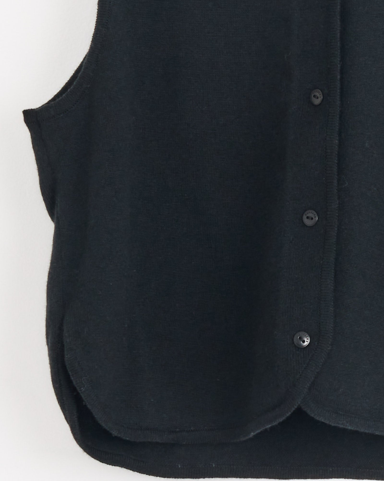 Close-up of the Cordera Merino Wool Waistcoat in Black, a sleeveless vest with three front buttons, shown from the side against a plain white background.