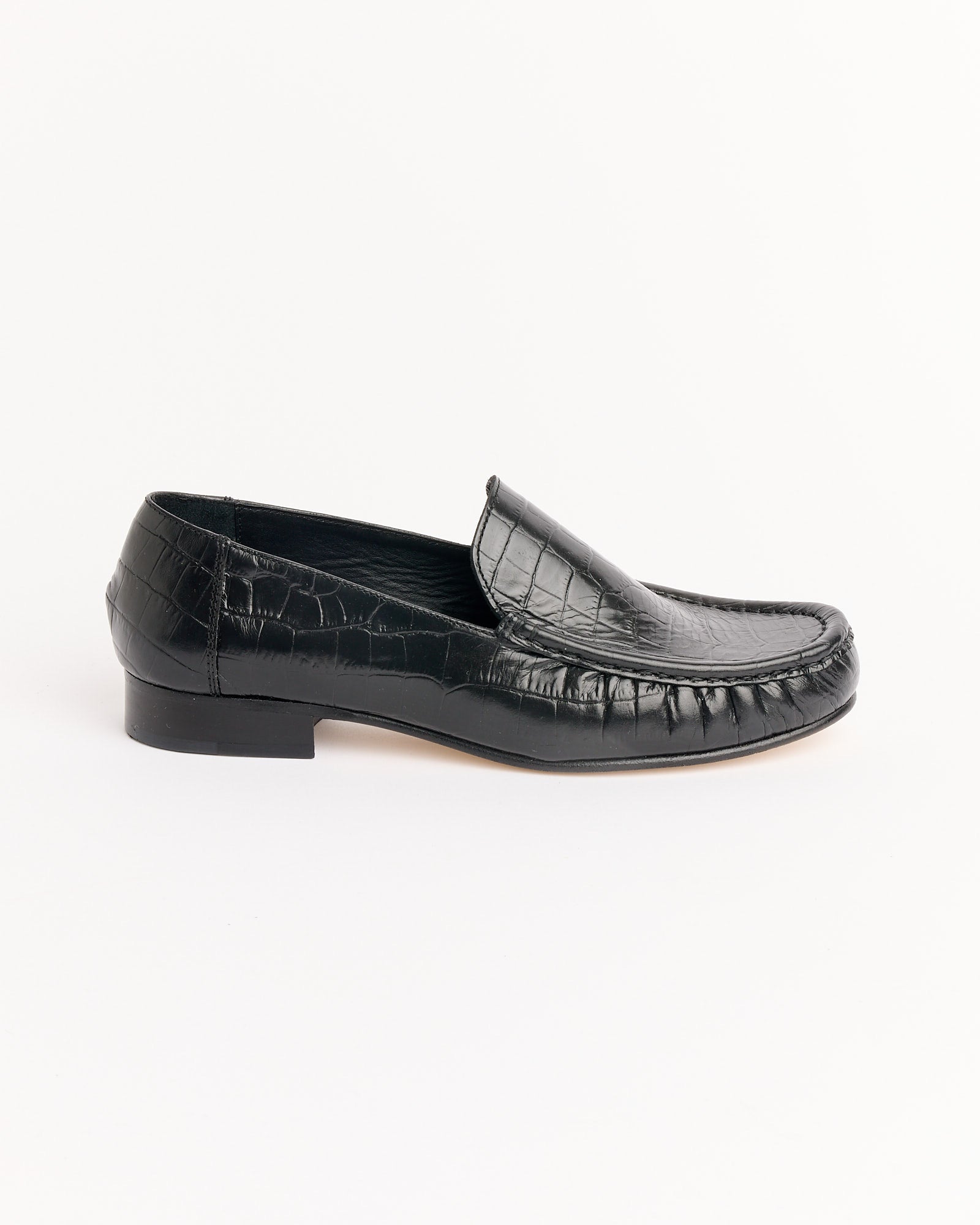 The Cordera Leather Loafer in Black Croco features a crocodile texture, low heel, and classic design, shown on a plain white background. For sizing or fit questions, our online chat is here to assist.