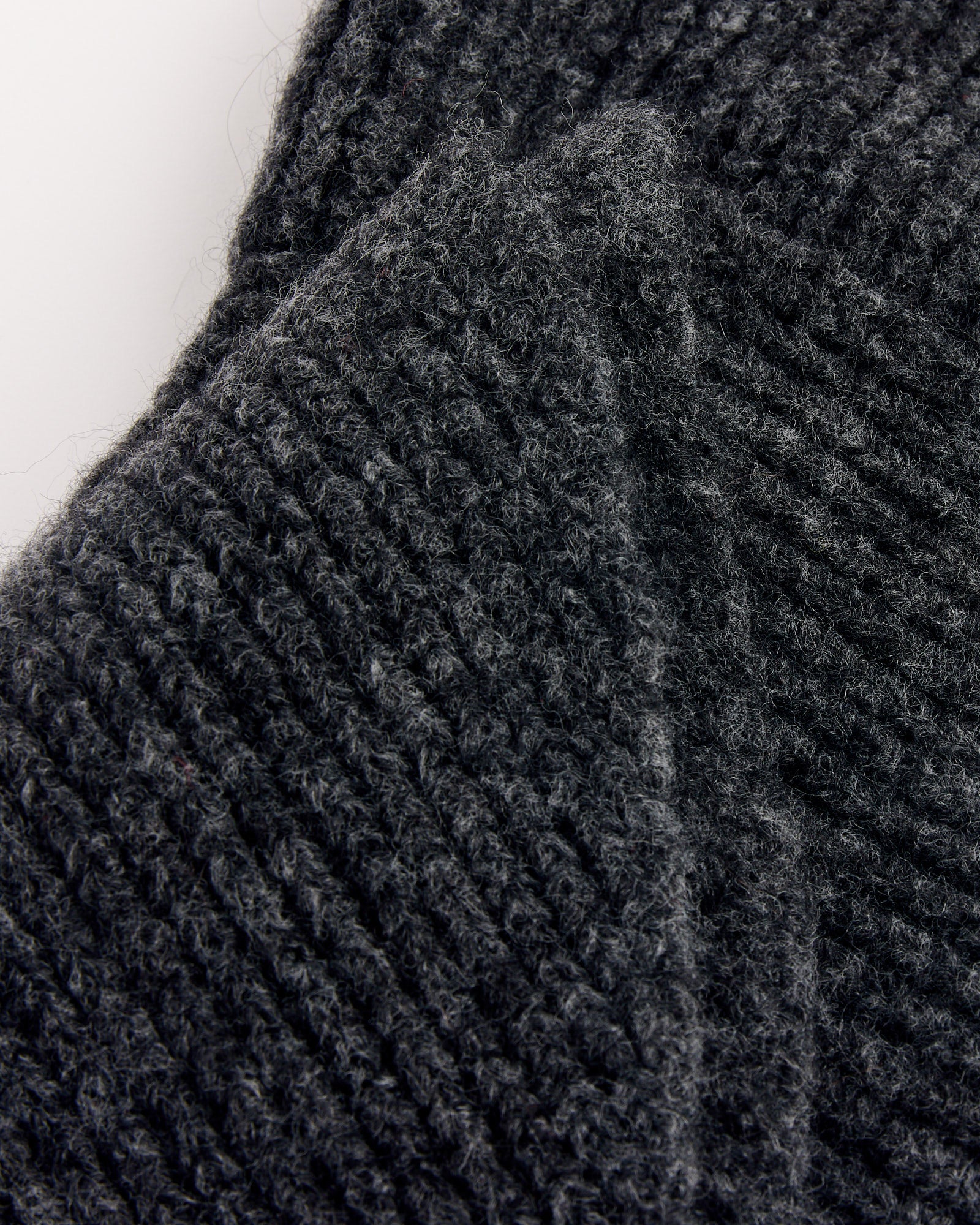 Close-up of the Paloma Wool Coucou Bonnet in Dark Grey, featuring soft, fuzzy ribbed knit and visible stitching details, expertly crafted from mulesing-free wool.