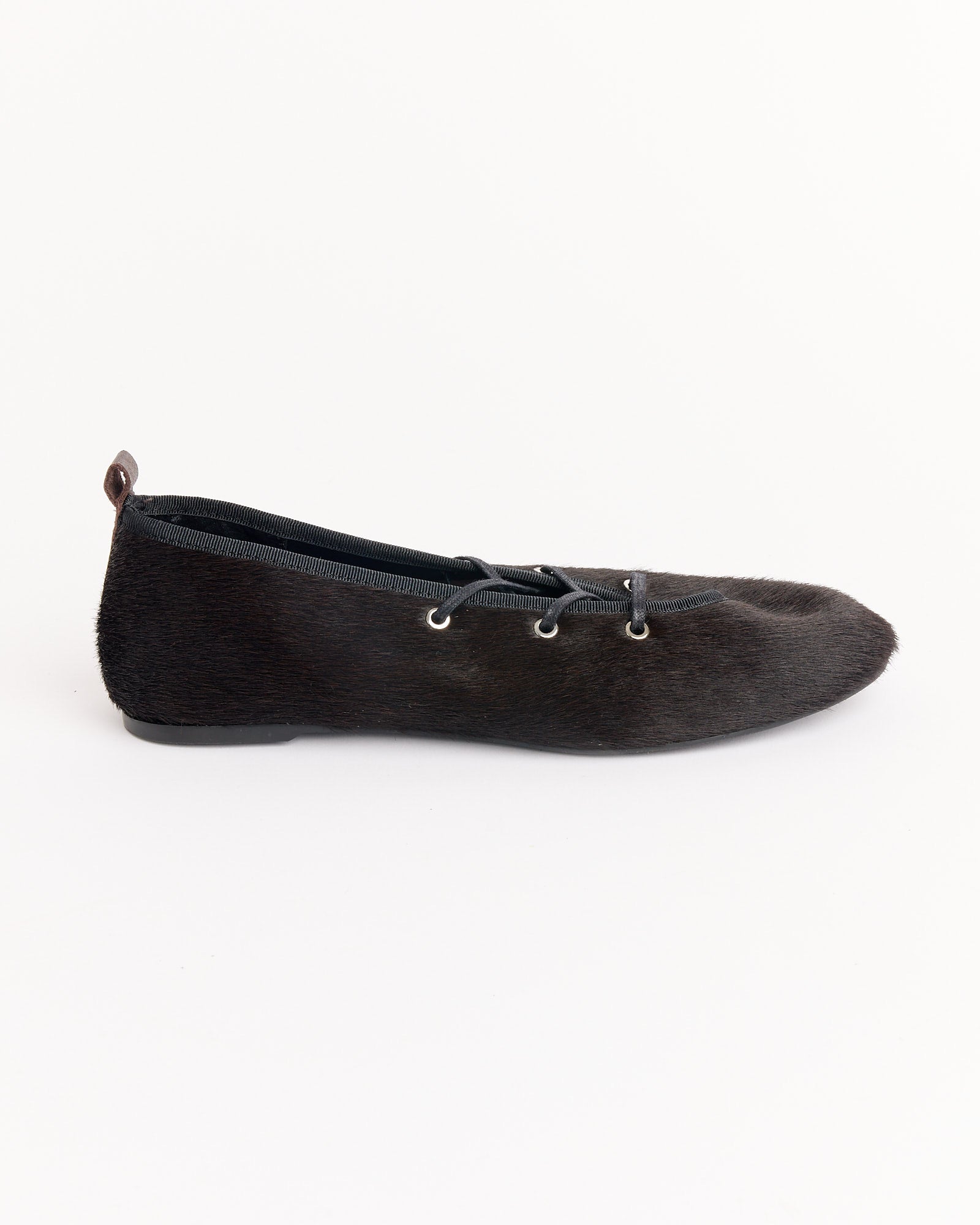 The Pina Ballet Flat in Brown by Paloma Wool features a haircalf leather texture, lace-up front with silver eyelets, small heel pull tab, and is shown in profile against a plain white background.