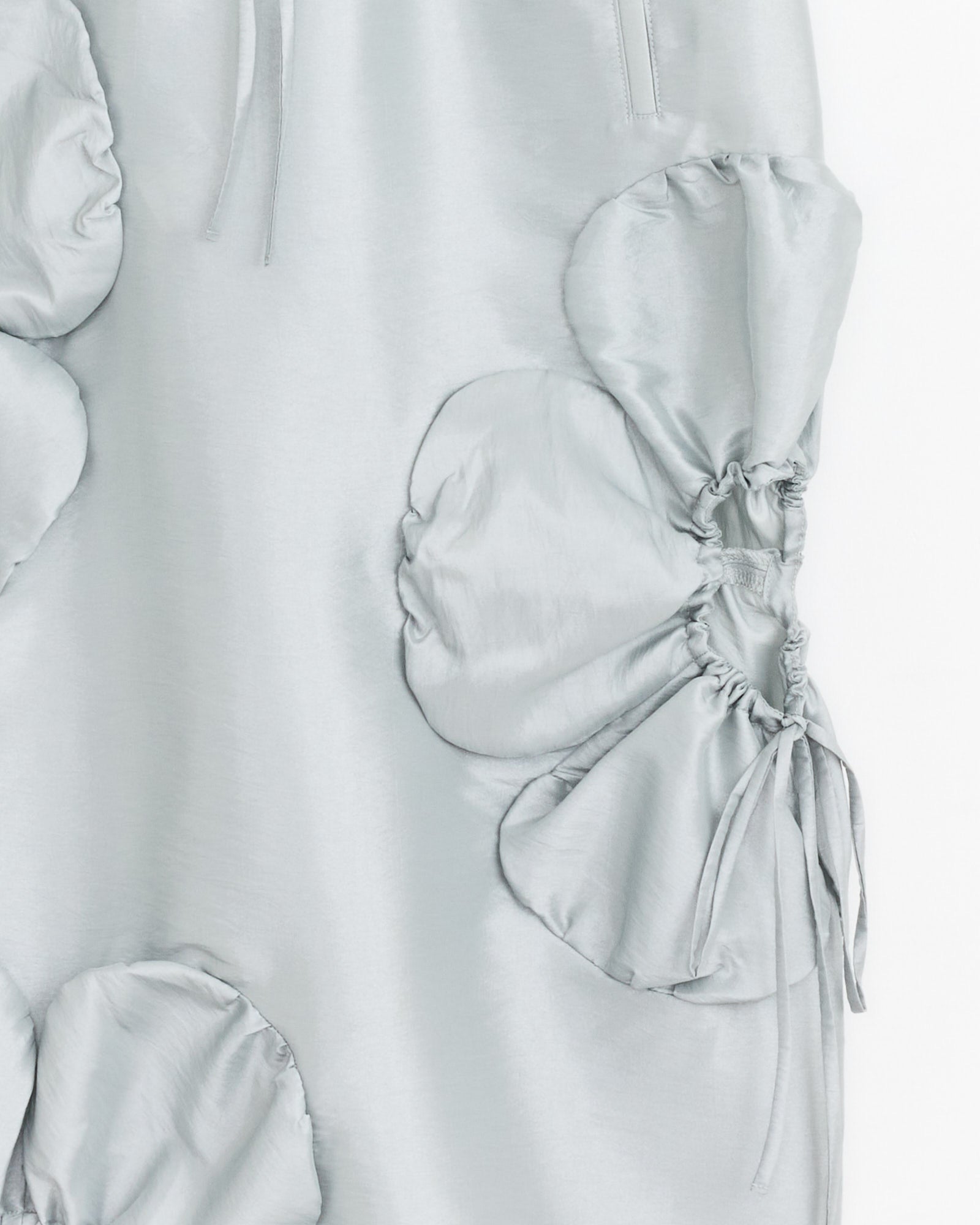 Close-up of the J. Kim Flower Skirt in Silver, crafted from lightweight nylon with large circular gathers, ruched texture, and adjustable flower cut-outs with drawstring ties on one side.