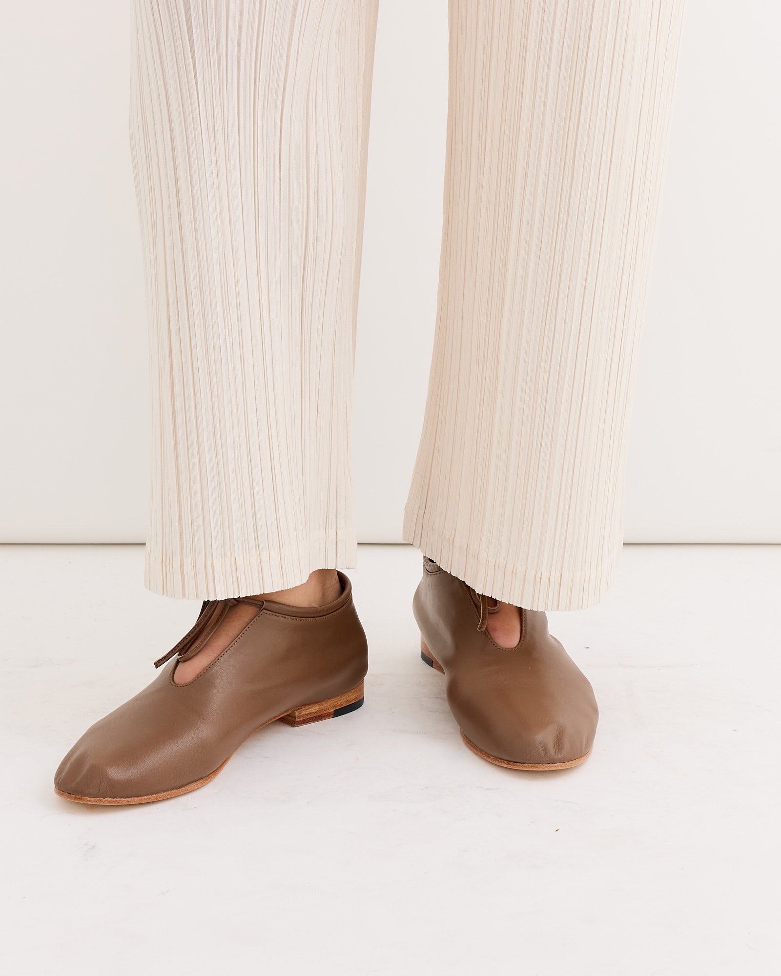 A person wearing the Bootie in Vision by Martiniano, a stylish lace-up bootie crafted from soft, handcrafted kid leather.