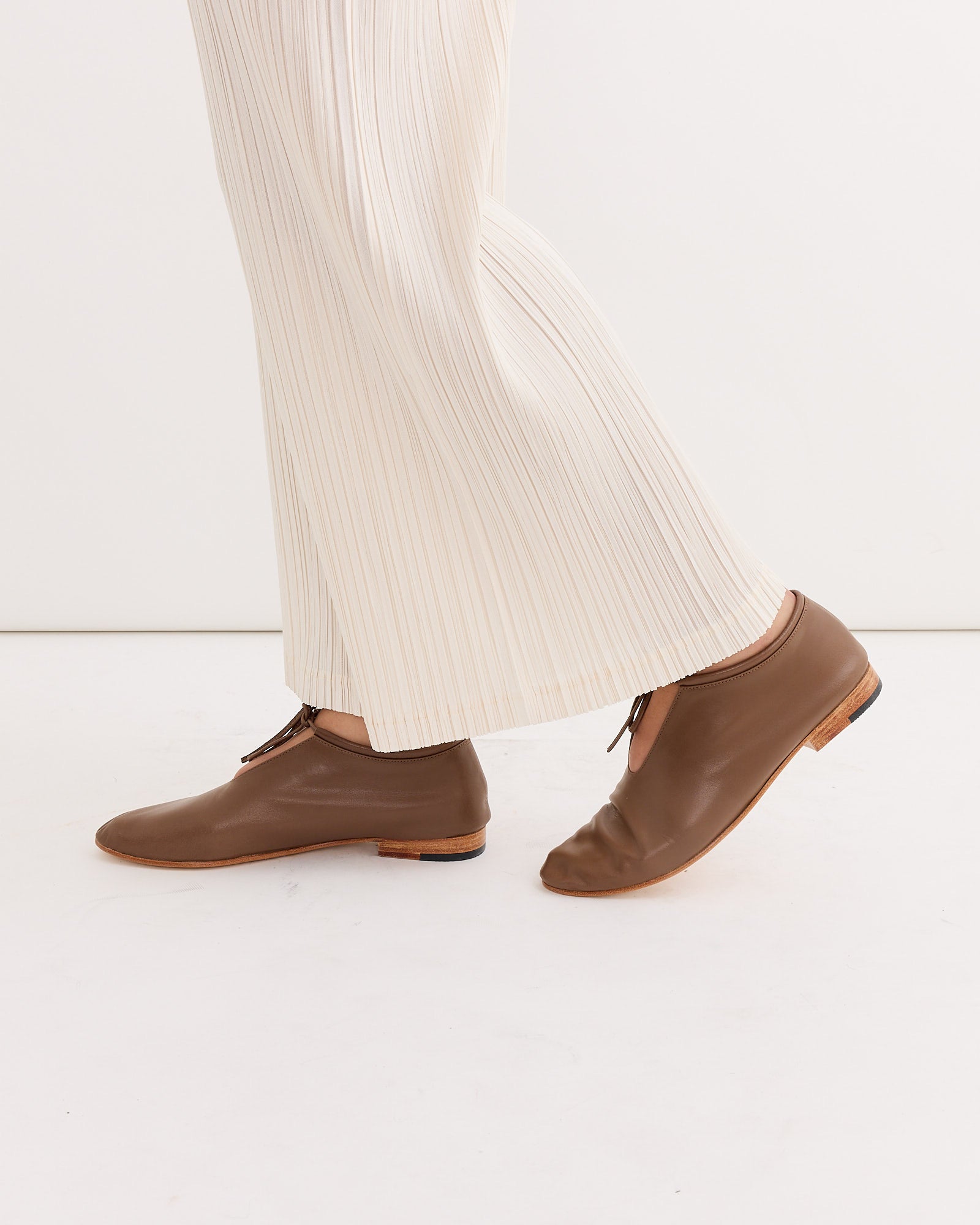 A person’s legs and shoes, featuring the stylish Martiniano Bootie in Vision.