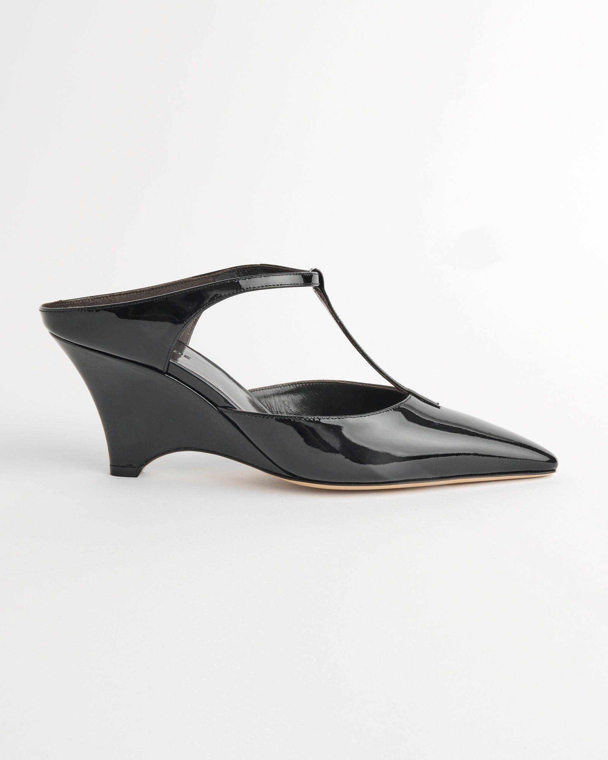 The Victoria T-Bar Wedge in Black by Le Monde Beryl is a handcrafted black vernice leather mule with a pointed toe, T-Bar wedge, and curved heel, shown against a plain white background.
