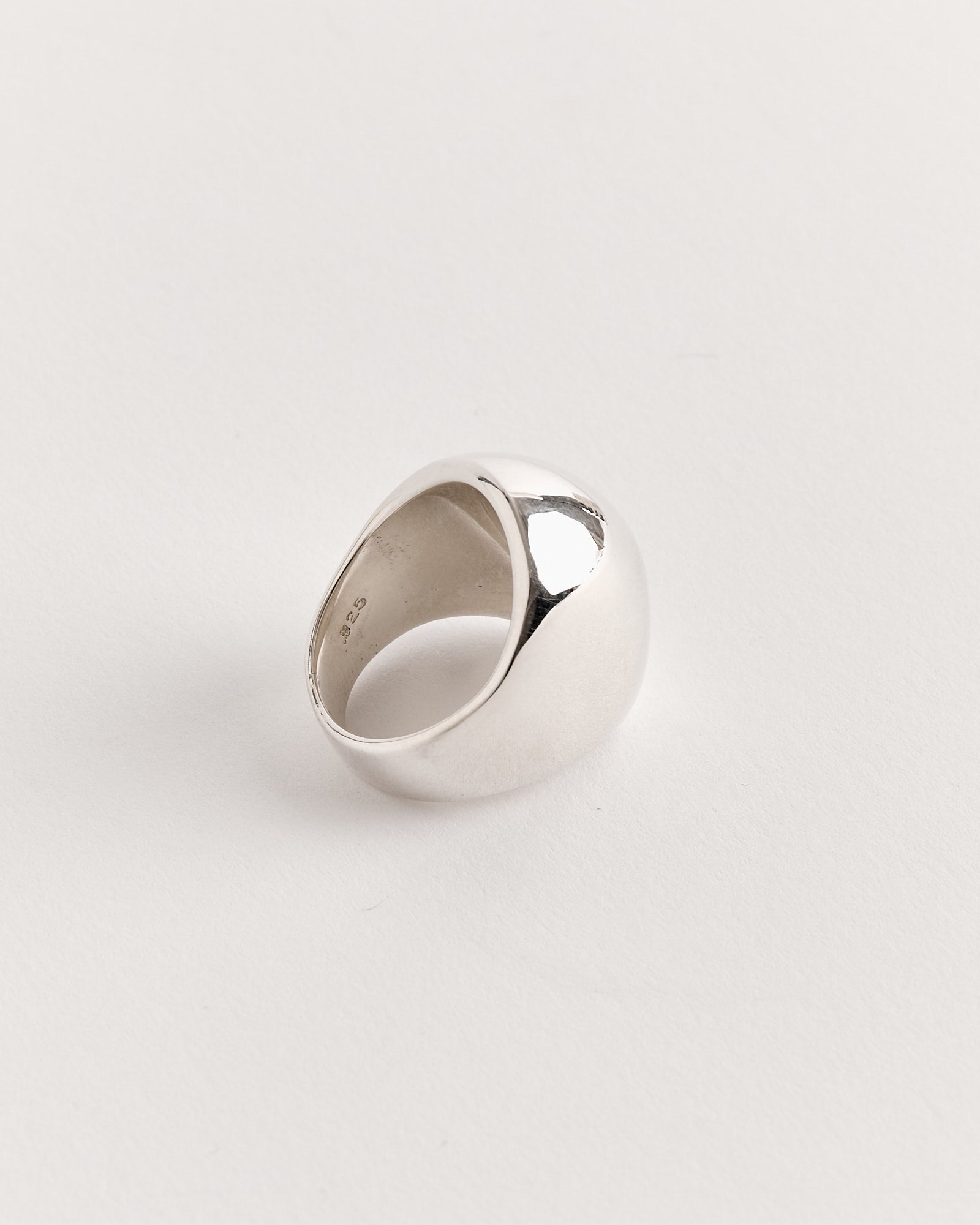 The Sophie Buhai Dome Ring in Sterling Silver, featuring a thick, polished band with a smooth, rounded surface, is displayed on a plain white background. Light reflects gently from the partially visible interior of the ring.