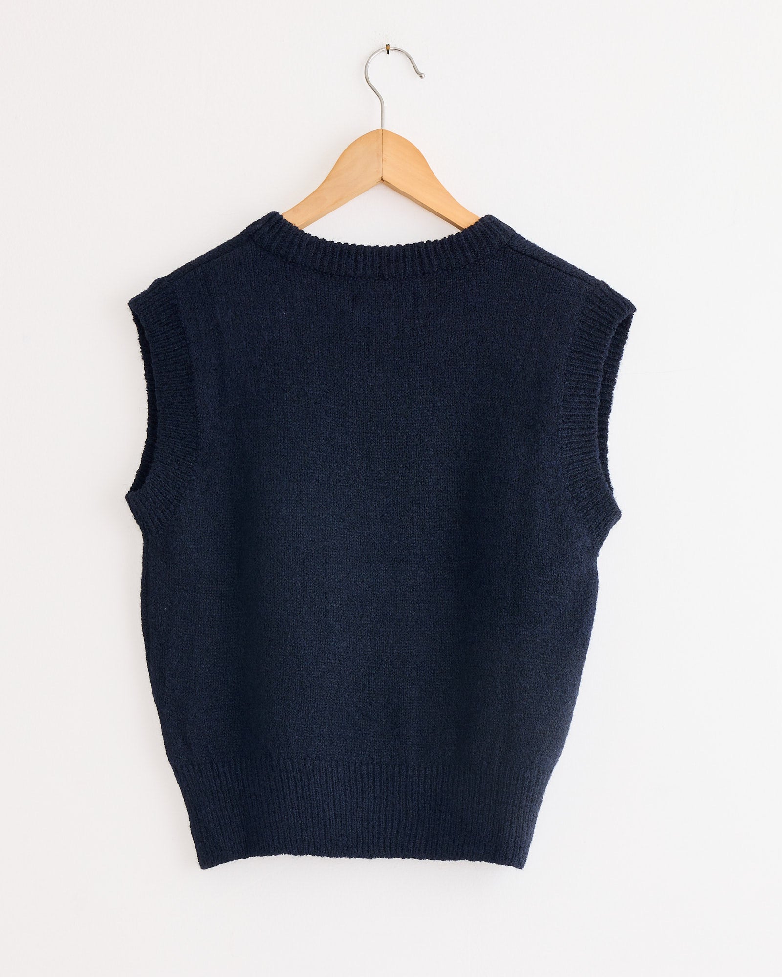 A Mijeong Park Wool Blend V-Neck Vest in navy styled on a swinger.