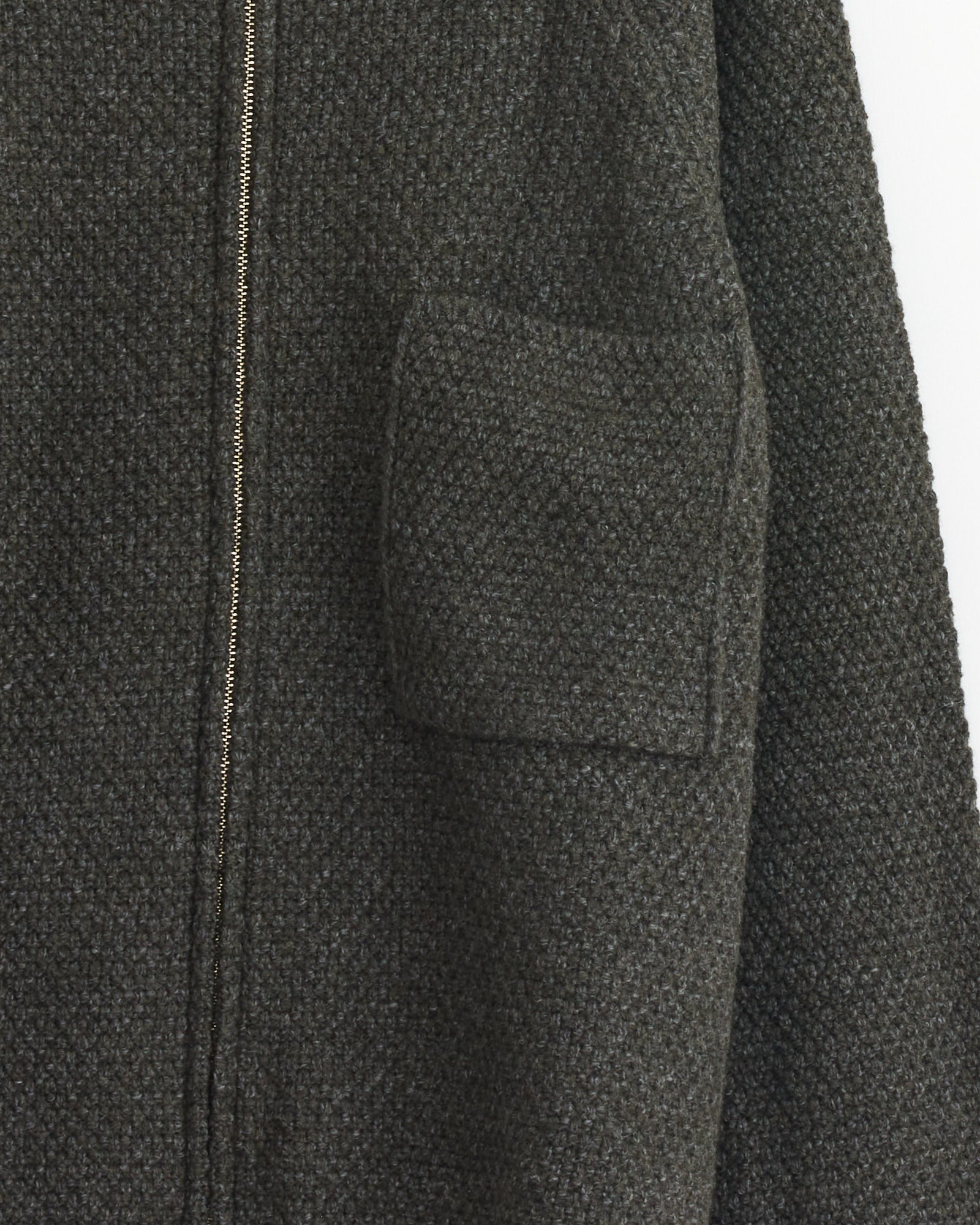 Close-up of the Still By Hand 5G Knitted Blouson in Melange Khaki, made in Japan, with a front zipper, square chest pocket, and visible merino wool texture on the sleeve and upper body.