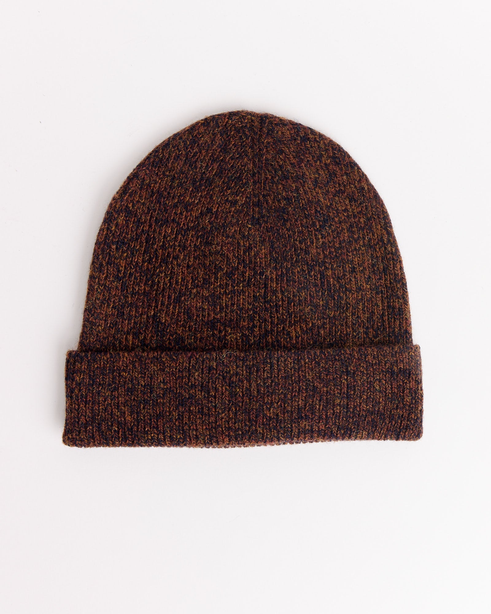 The 7G Knit Cap in Melange Brown by Still By Hand features a brown and black speckled knit and a folded brim, shown laid flat on a white background.
