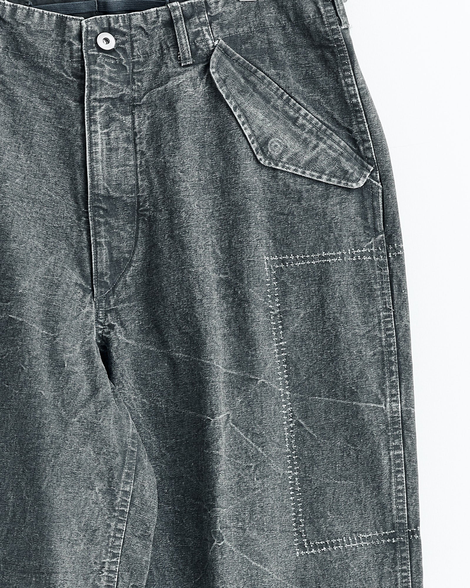 Close-up of A.PRESSE M-51 Custom Pant in olive, showcasing a wide-tapered fit, large angled flap pocket, white contrast stitching, and a visible square patch detail on the thigh.