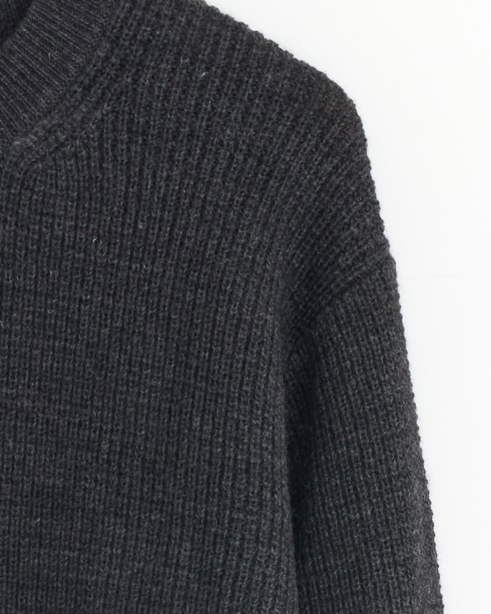 Close-up of the Knit Sweater in Top Grey by Comme Des Garçons Homme, featuring heavyweight ribbed knit wool. The image shows the upper body and shoulder against a plain white background, highlighting the brand’s signature minimalist style.