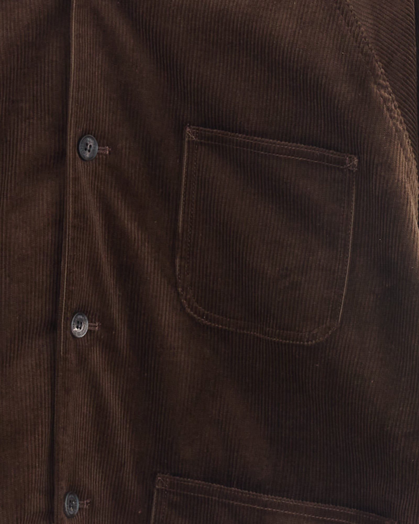 Close-up of the Needlecord Shirt in Brown by Comme Des Garçons Homme, made in Japan. Features a vertical button row, right chest pocket, and visible textured fabric with detailed stitching.