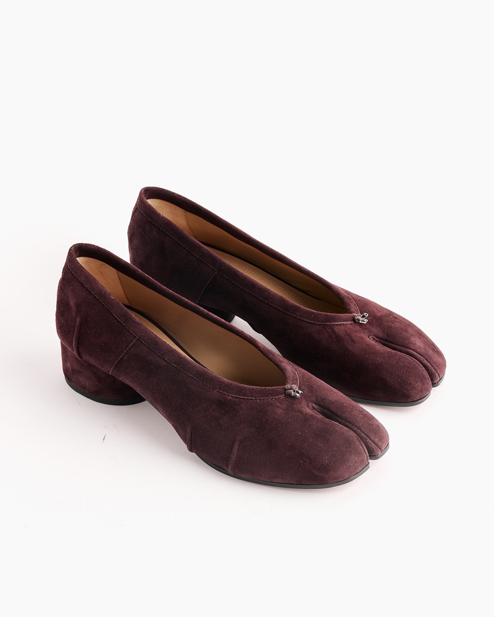 The Maison Margiela Tabi New Ballerina in Bordeaux features a low block heel, ballerina style, and signature split-toe design in dark burgundy suede, shown on a white background.