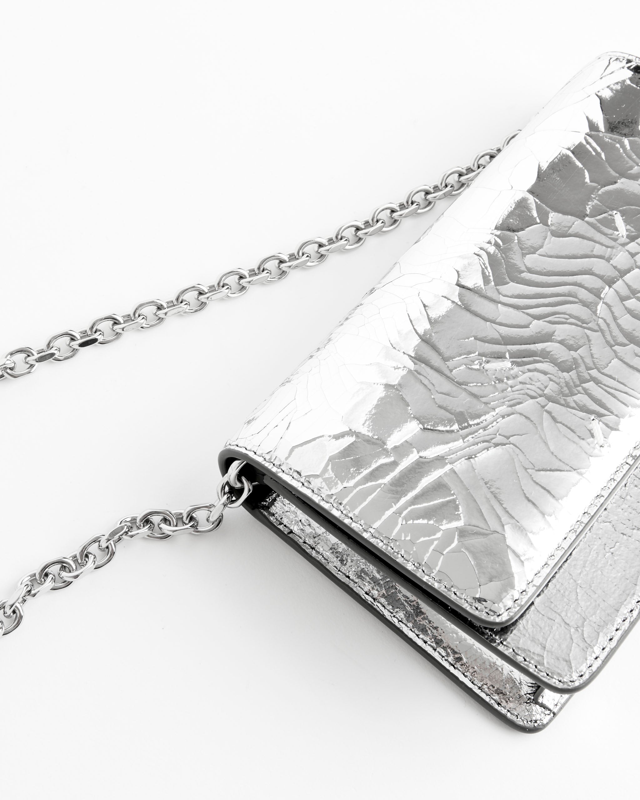 The Maison Margiela Broken Mirror Chain Wallet features a metallic silver, cracked finish and a silver chain strap, shown on a white background.