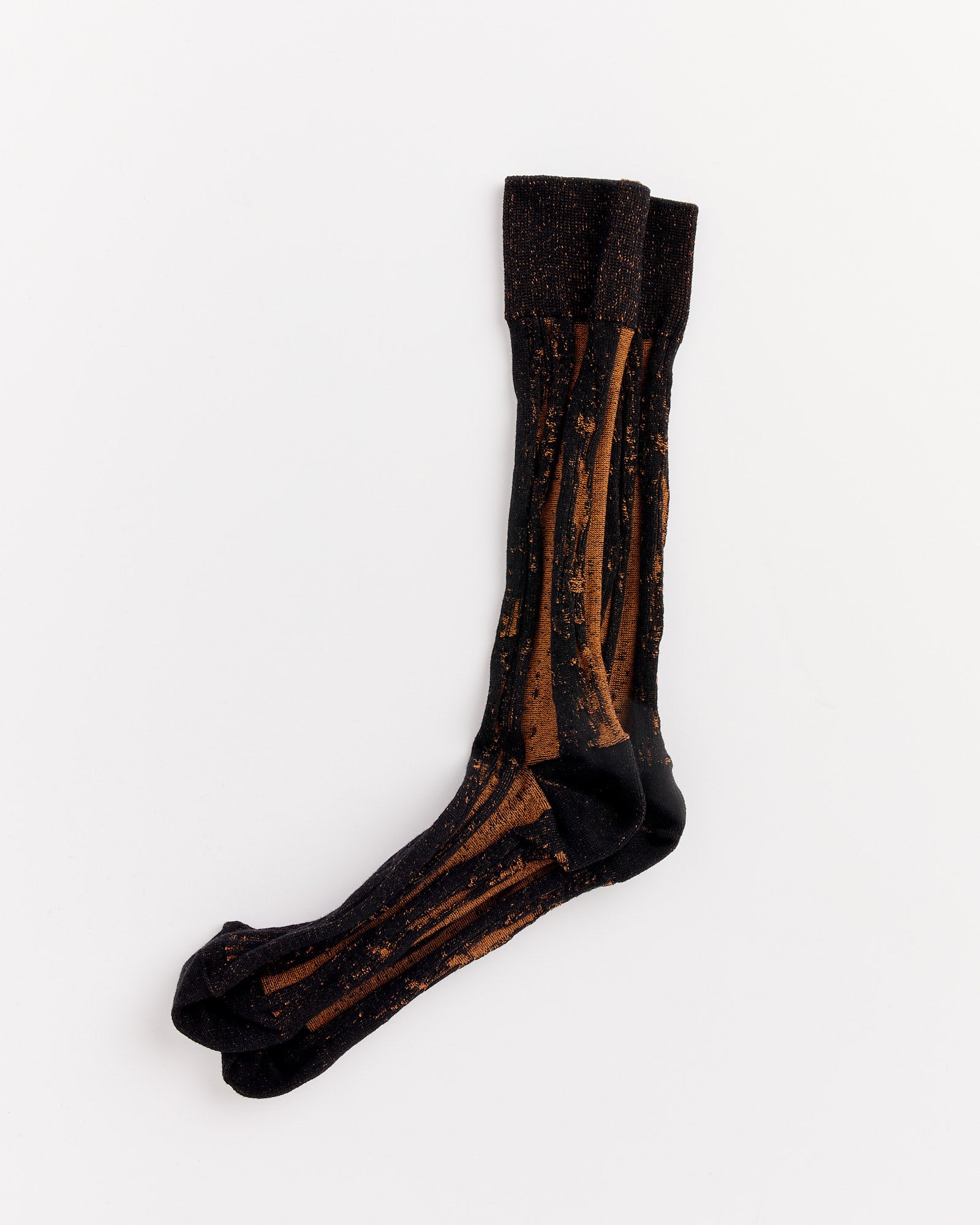A pair of IM MEN Cotton Jacquard Socks in Black with a brown abstract streak pattern, laid flat on a white background. Made in Japan.