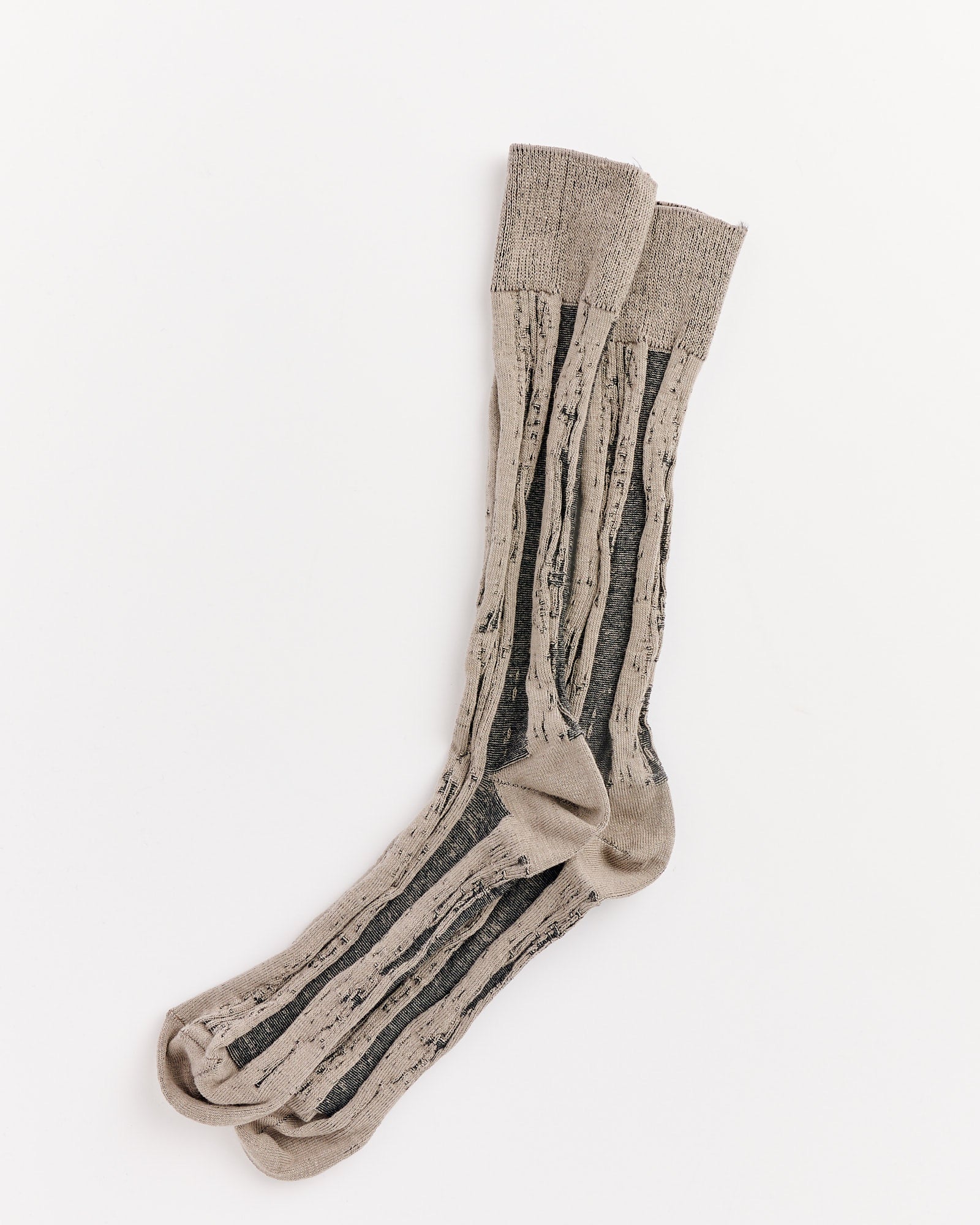 A pair of IM MEN Cotton Jacquard Socks in Sand Beige with vertical black stripes, shown laid flat on a white background. Made in Japan.