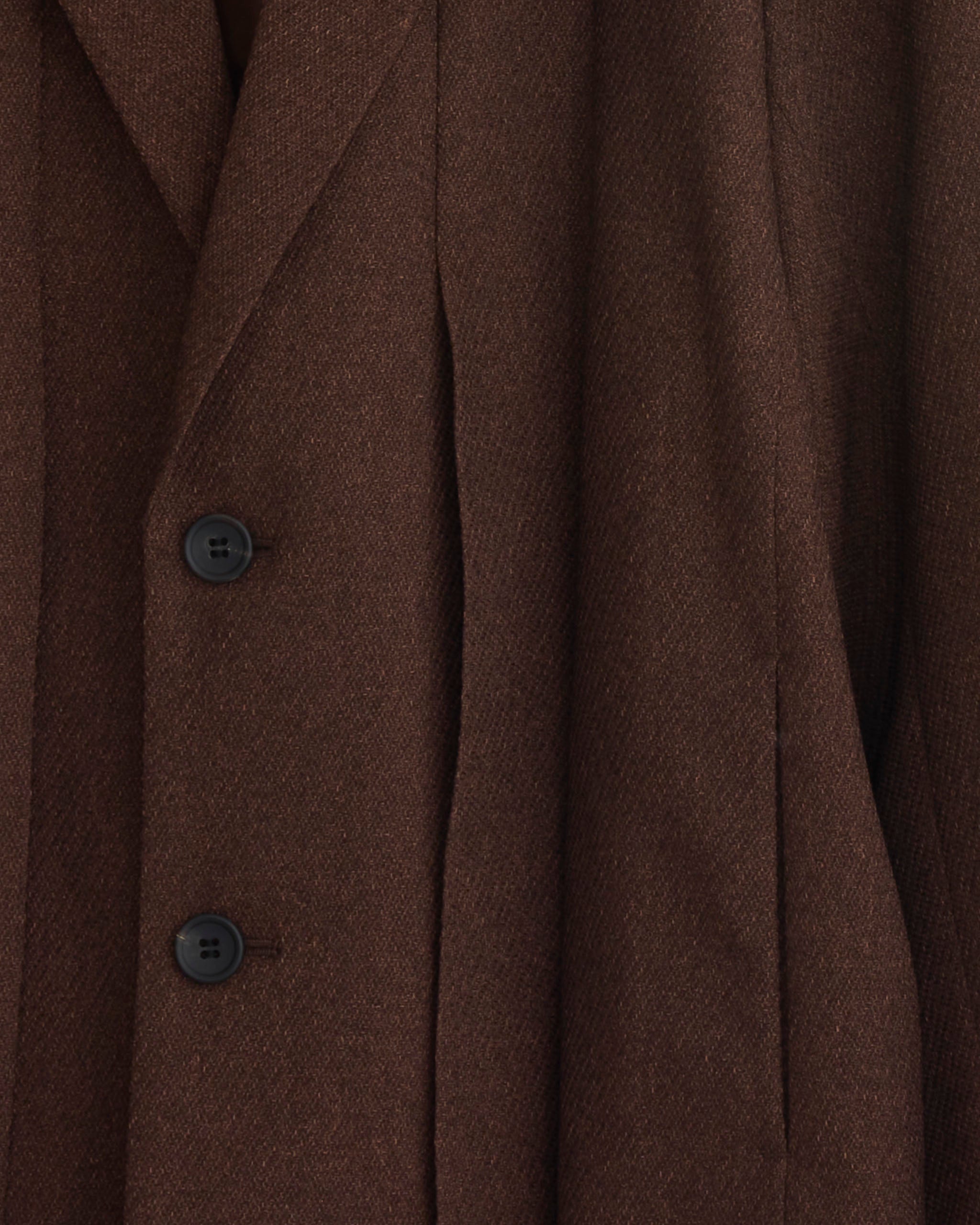 Close-up of the IM MEN Wool Like Tweed Blazer in Brown, featuring two black buttons, a notched lapel, and textured fabric with tailored seams.