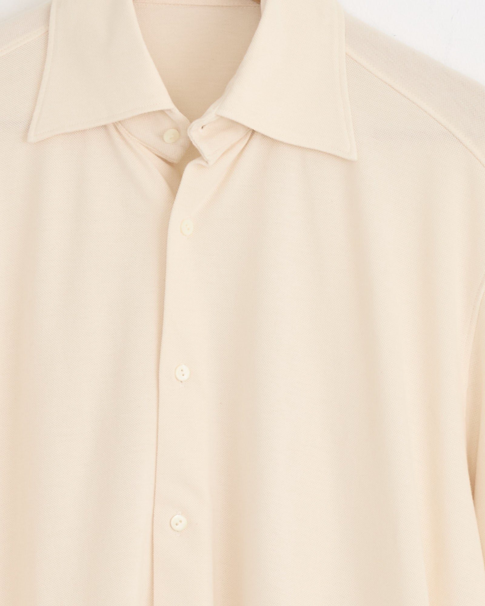 A close-up of the Stoffa Spread Collar Shirt in Ivory, crafted from a cotton-silk blend with a pointed collar and four visible buttons, displayed against a white background.