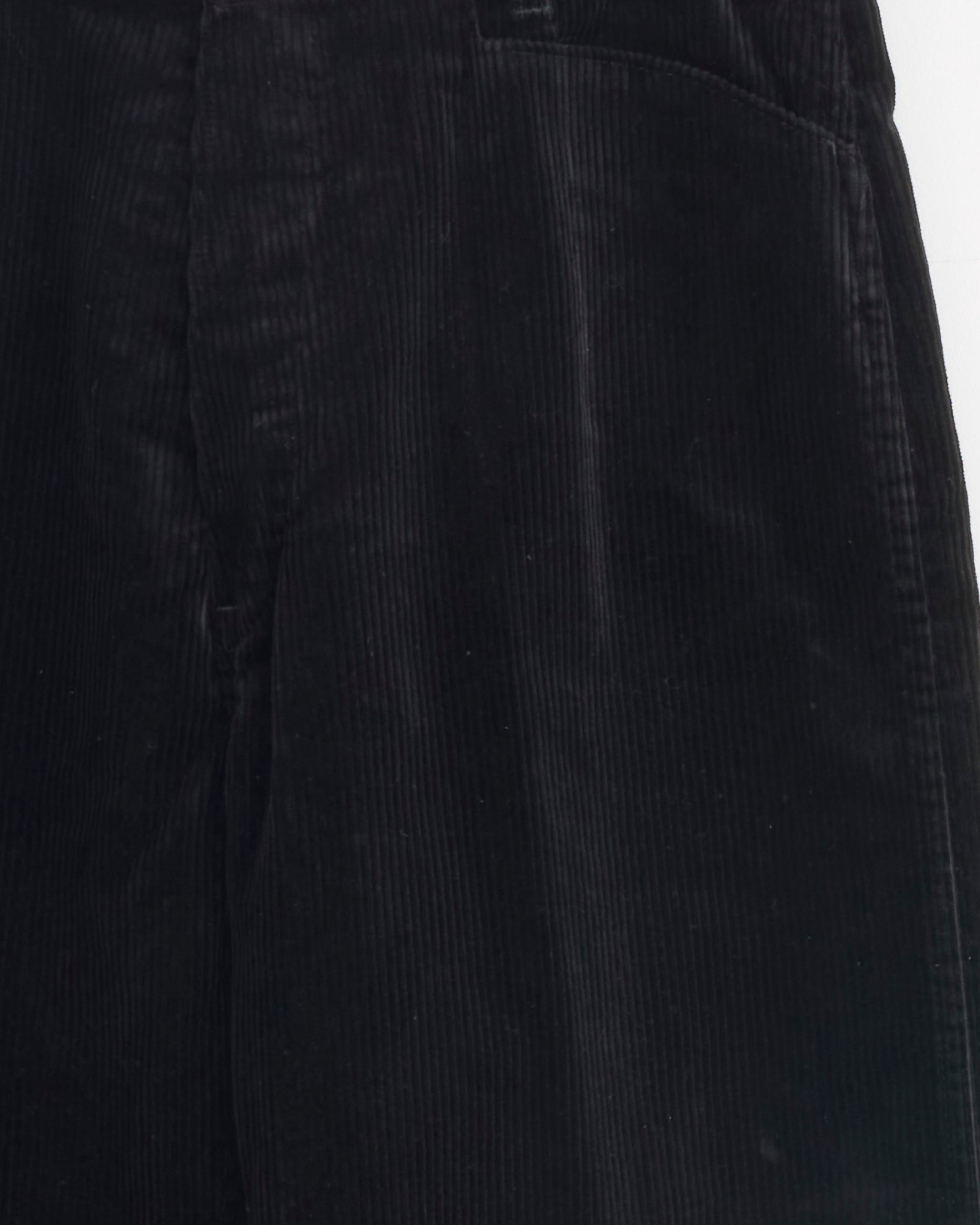 Close-up of the Comoli Corduroy Work Pant in Black, showcasing its distinct vertical ribbed 100% cotton texture and a section of the waistband.