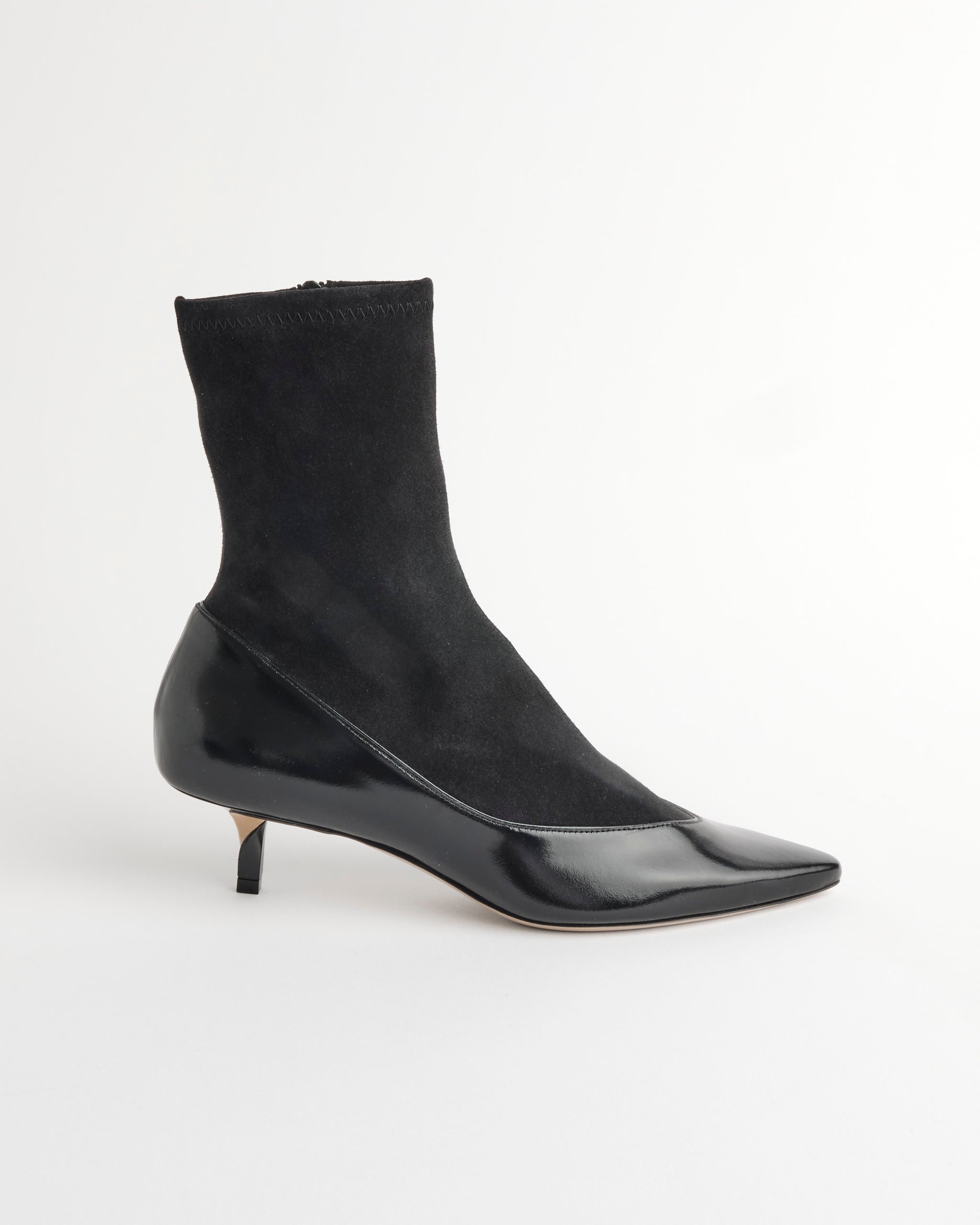 The Jacquemus Les Bottines Tourni Pump Boot in Black features a stretch suede, sock-like upper with shiny leather, a pointed toe, and kitten heel—displayed on a plain white background.