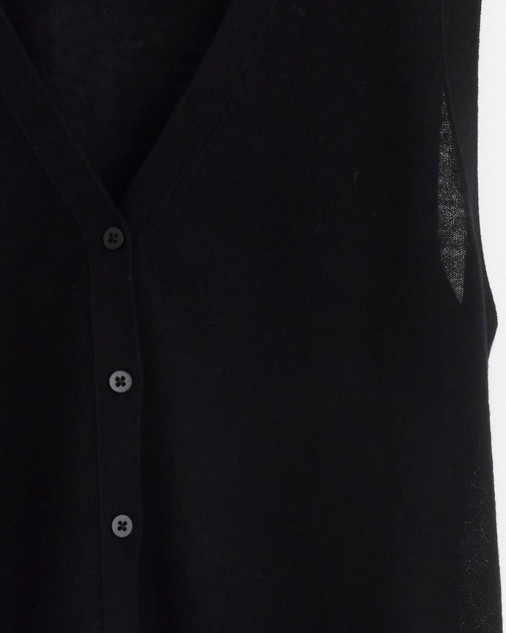 Close-up of the ST. AGNI Oupa Vest in Black—a sleeveless, lightweight knit vest featuring four black buttons and a deep V-neckline. The fabric is slightly sheer, highlighting its refined texture and modern design.