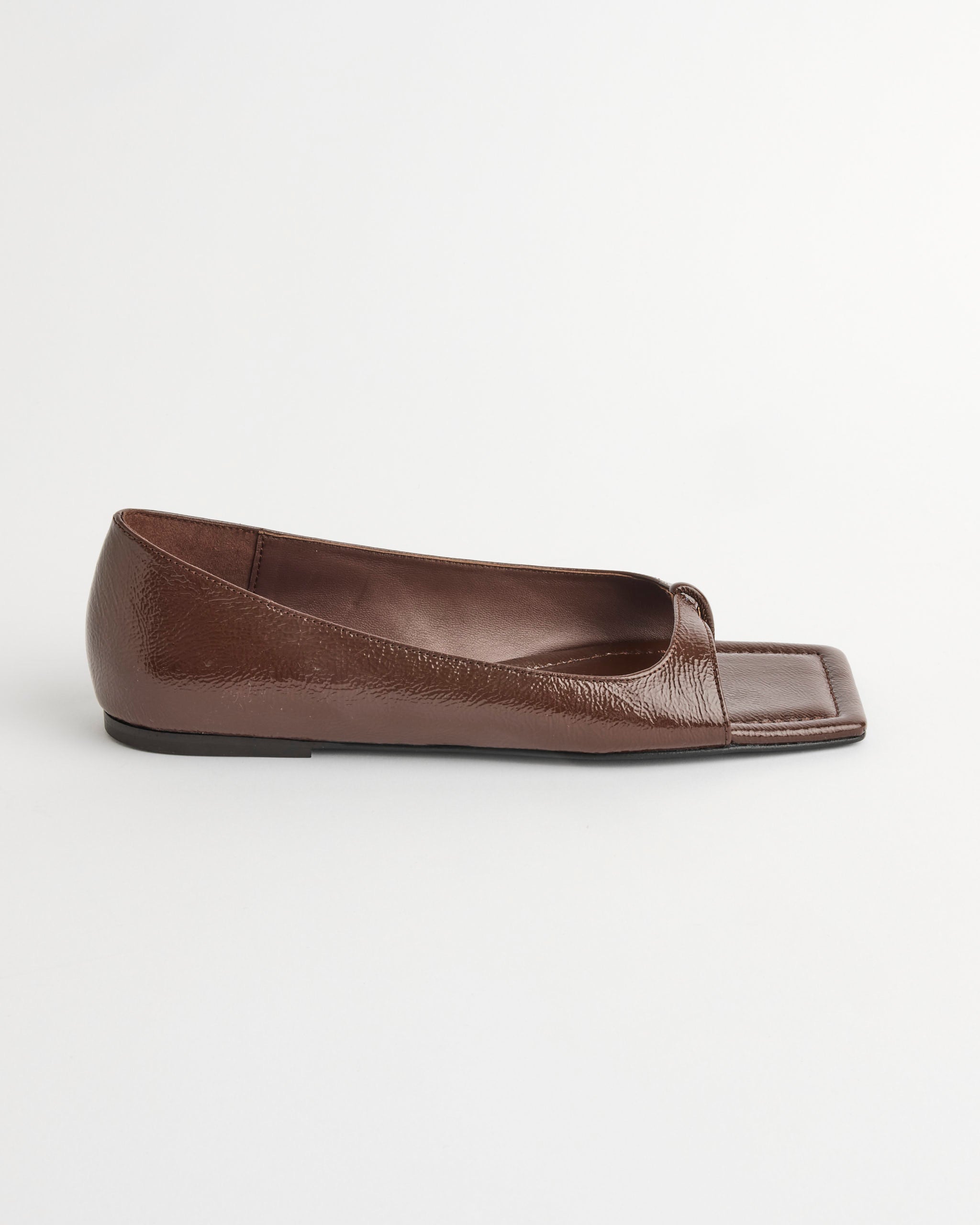 The ST. AGNI 90s Square Toe Flat Shoes in Patent Liqueur, featuring a minimal design, are photographed from the side against a plain white background.