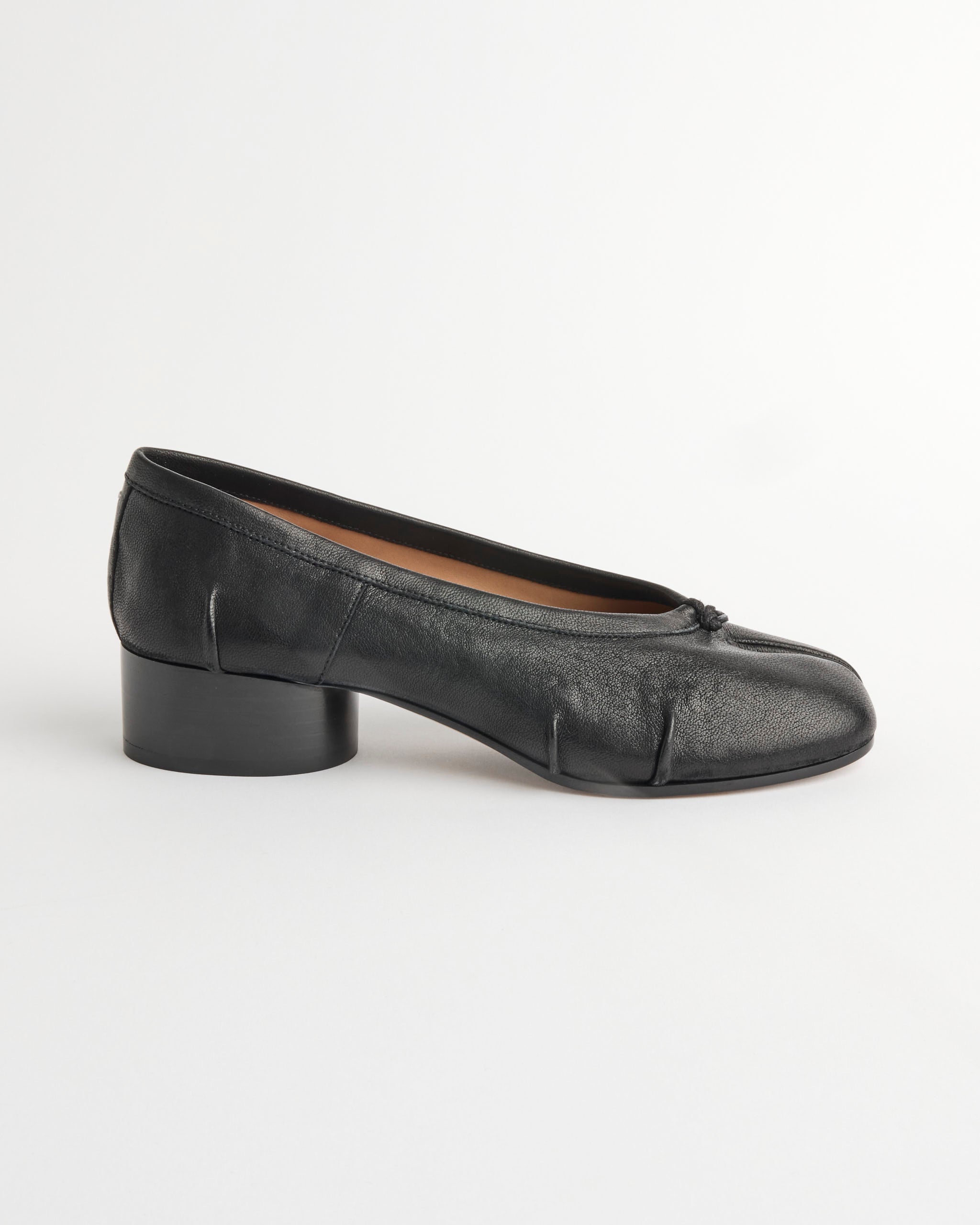 The Maison Margiela Tabi Ballerina New H30 in Black features black nappa leather, a low heel, rounded toe, seam details, and a small front bow, shown against a plain white background.