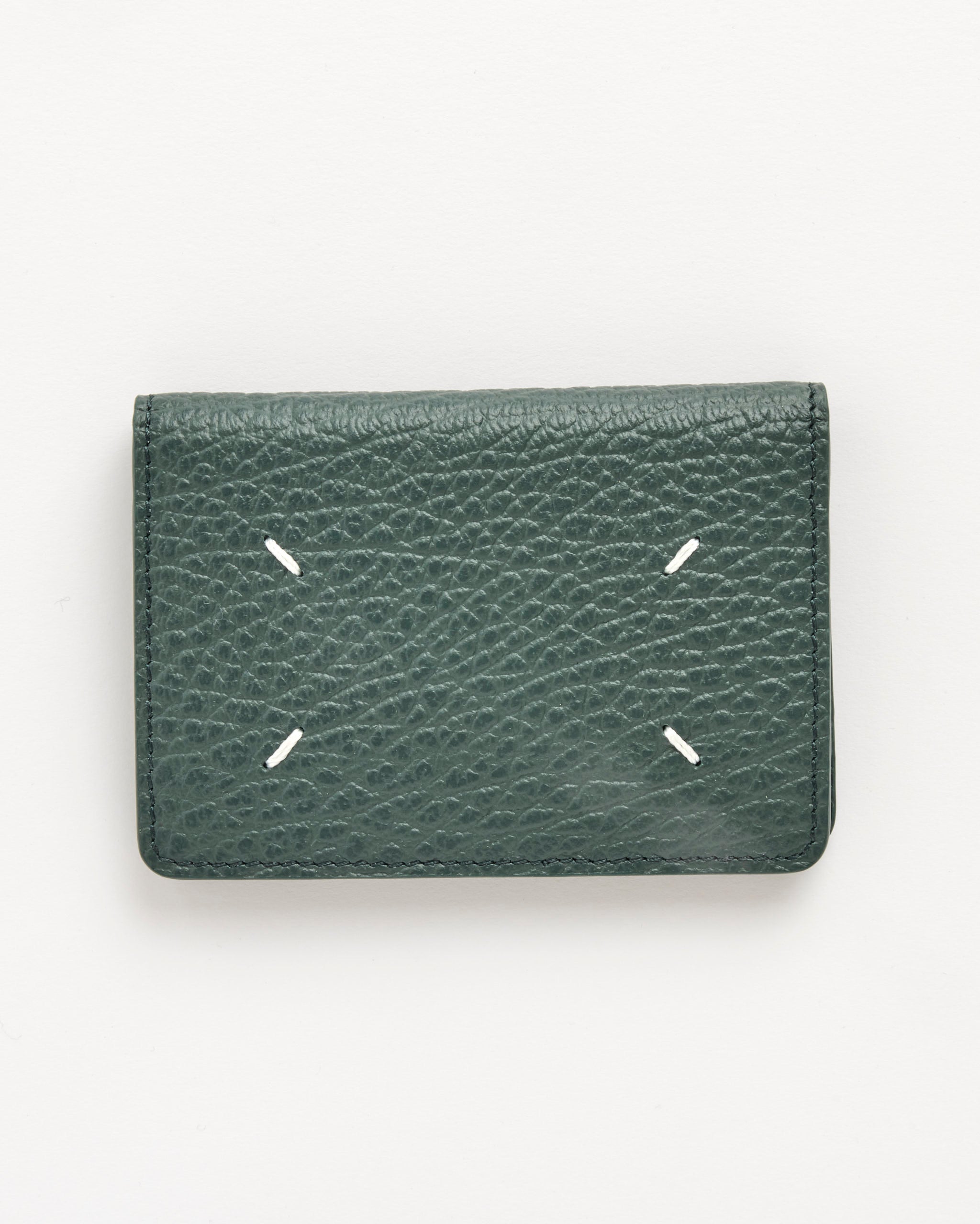 The Maison Margiela Card Holder Slim 2 in Bottle Green is crafted from embossed grainy leather and features four white diagonal stitches arranged in a square on the front, displayed against a plain white background.