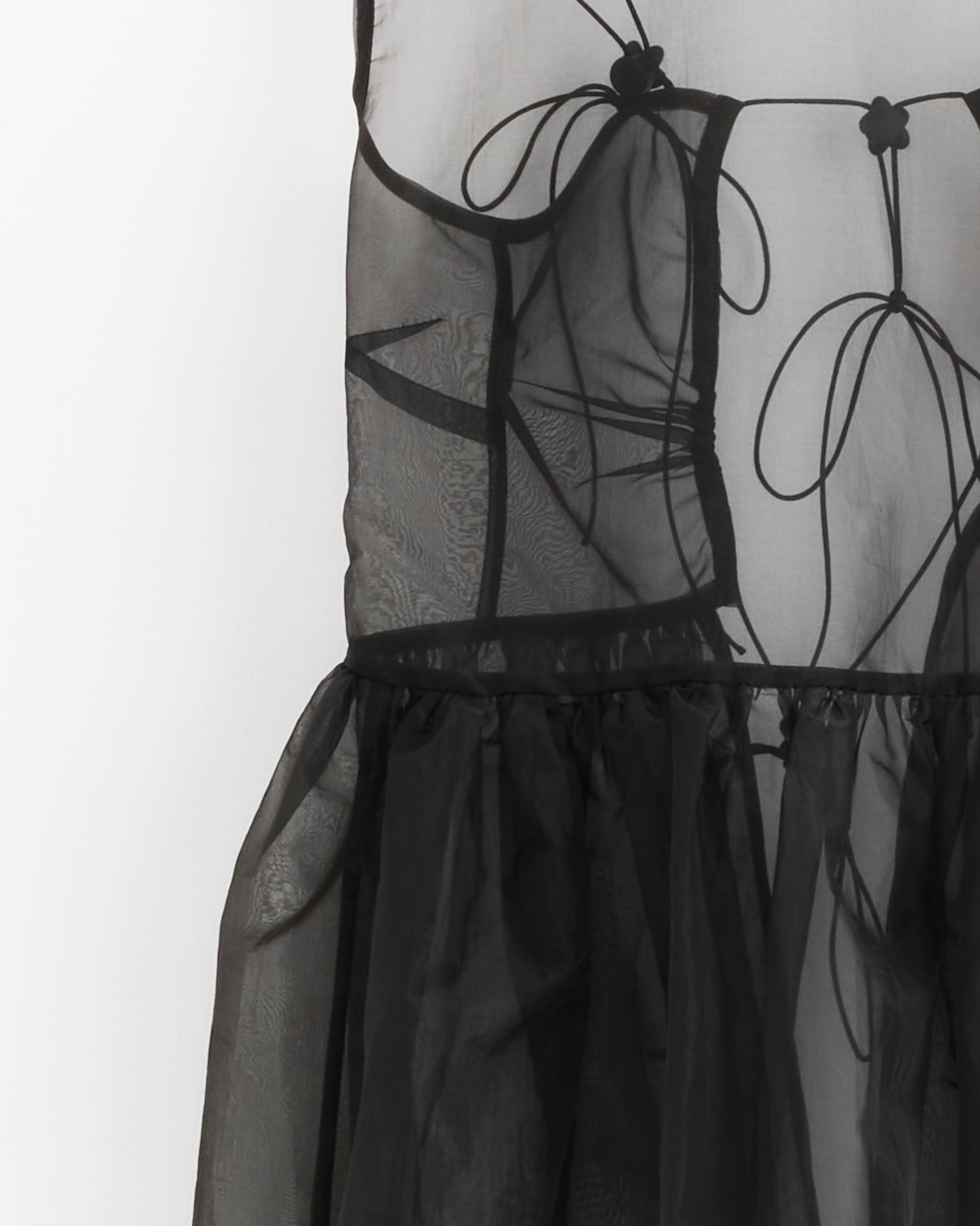 The Camilla Overlay Liquid Myrtia Dress in Black by Cecilie Bahnsen features sheer polyester, decorative stitching, bow accents on the bodice, a gathered waist, and a flowy skirt.