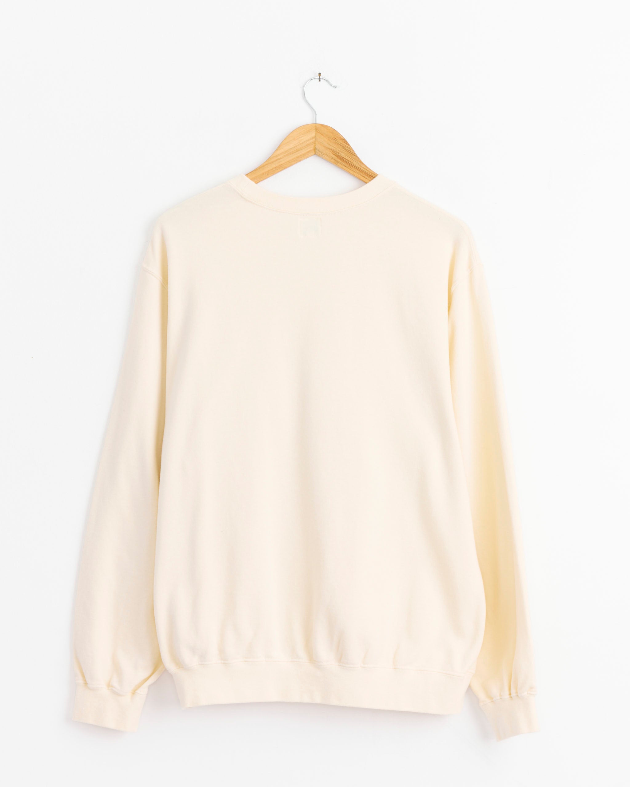 The orSlow French Terry Sweatshirt in Pale Yellow hangs on a wooden hanger against a white background. Shown from the back, this lightweight cotton sweatshirt features ribbed cuffs and hem.