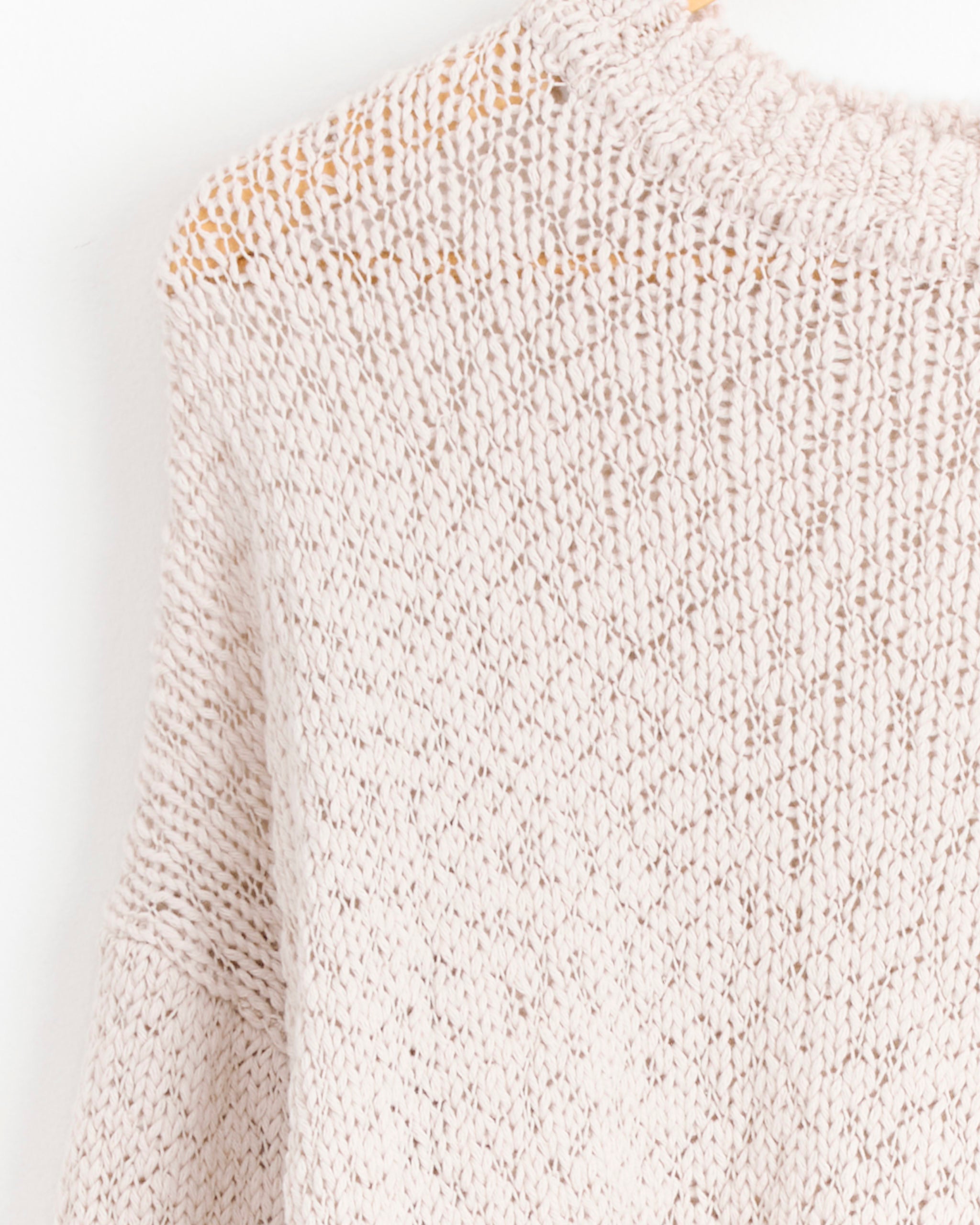 Close-up of the Risotto Sweater in Beige by Homme Plissé Issey Miyake, featuring a light beige knit cotton with a round neckline. The cropped image focuses on the upper part, highlighting its signature texture and weave.