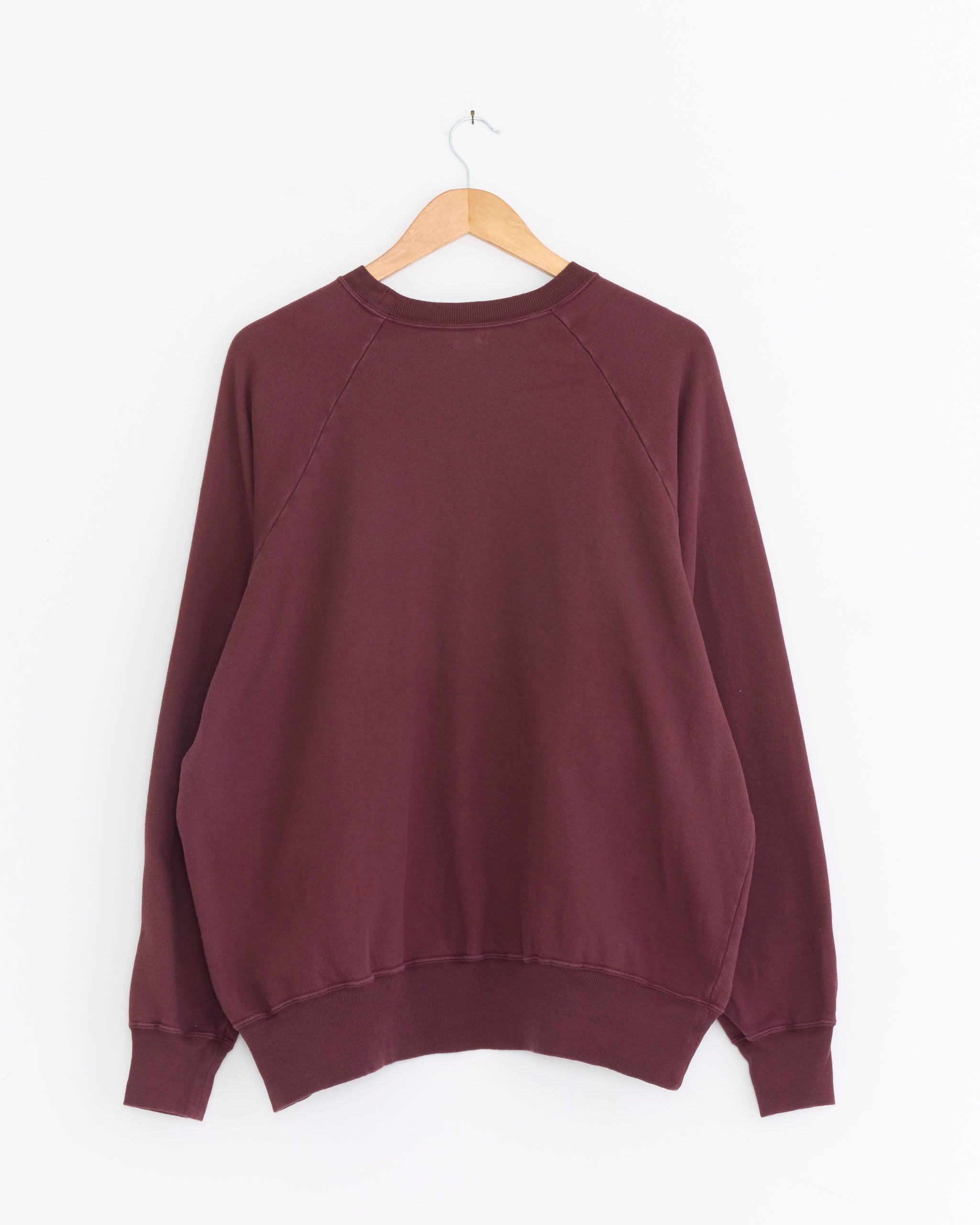 The A.PRESSE Vintage-Style Light Weight Sweatshirt in Burgundy is displayed with its back facing forward on a wooden hanger against a white background.