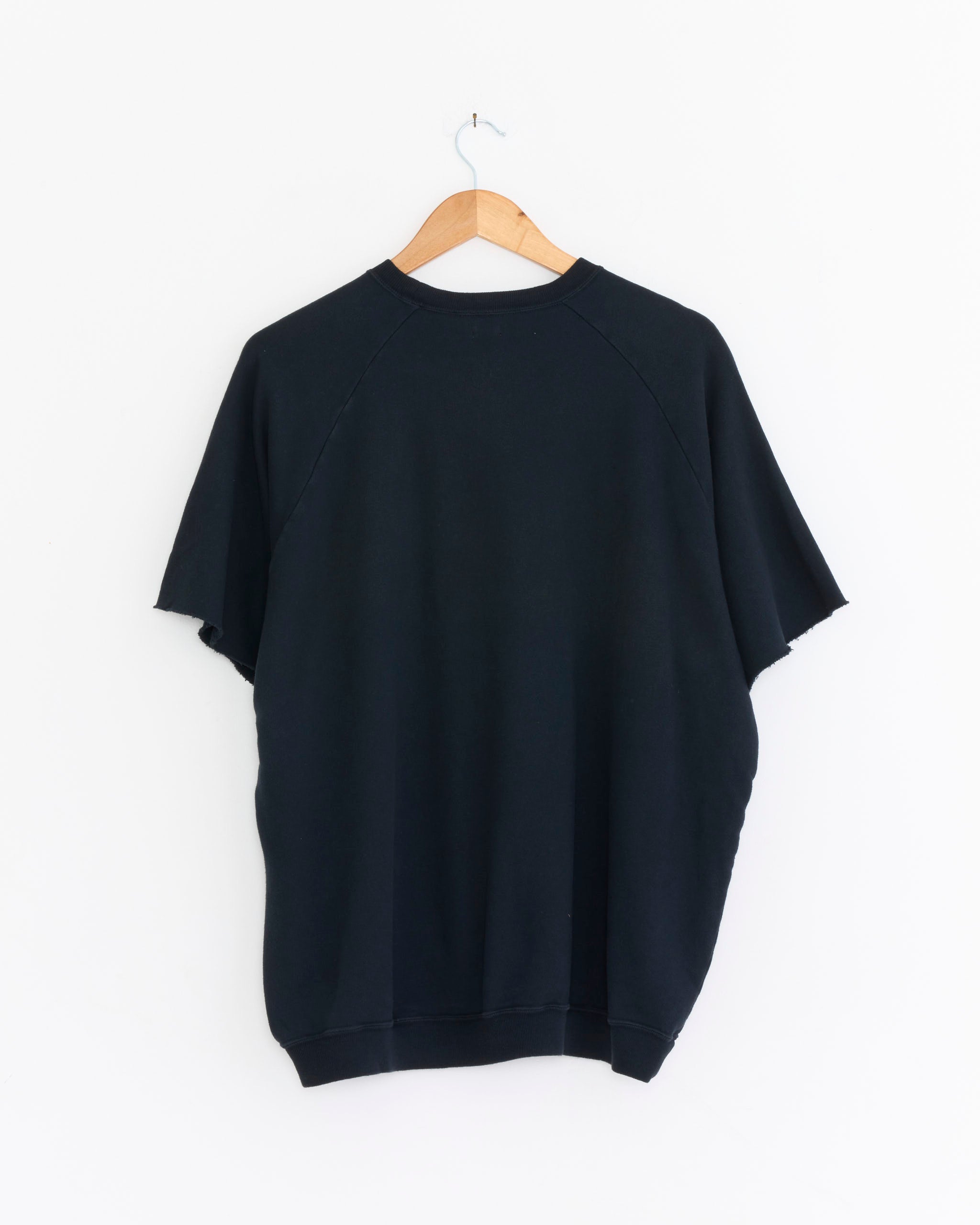 The A.PRESSE Vintage-Style Light Weight Sweatshirt in Black is shown from the back, hanging on a wooden hanger against a white background.