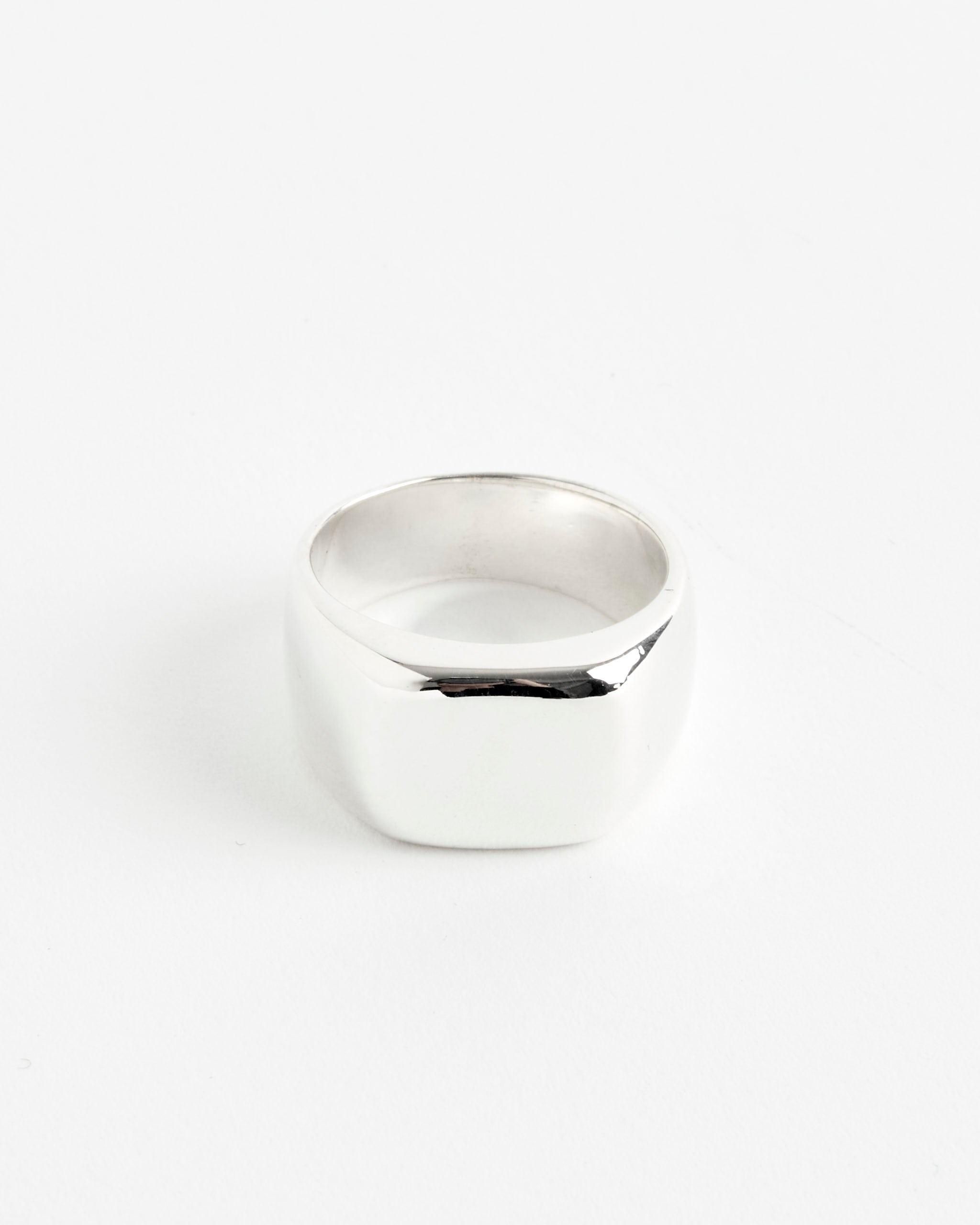 The Sophie Buhai Consigliere Ring—a shiny, wide silver band with a smooth finish—rests on a plain white background, perfect for any fit. For sizing help, connect with our online chat support.