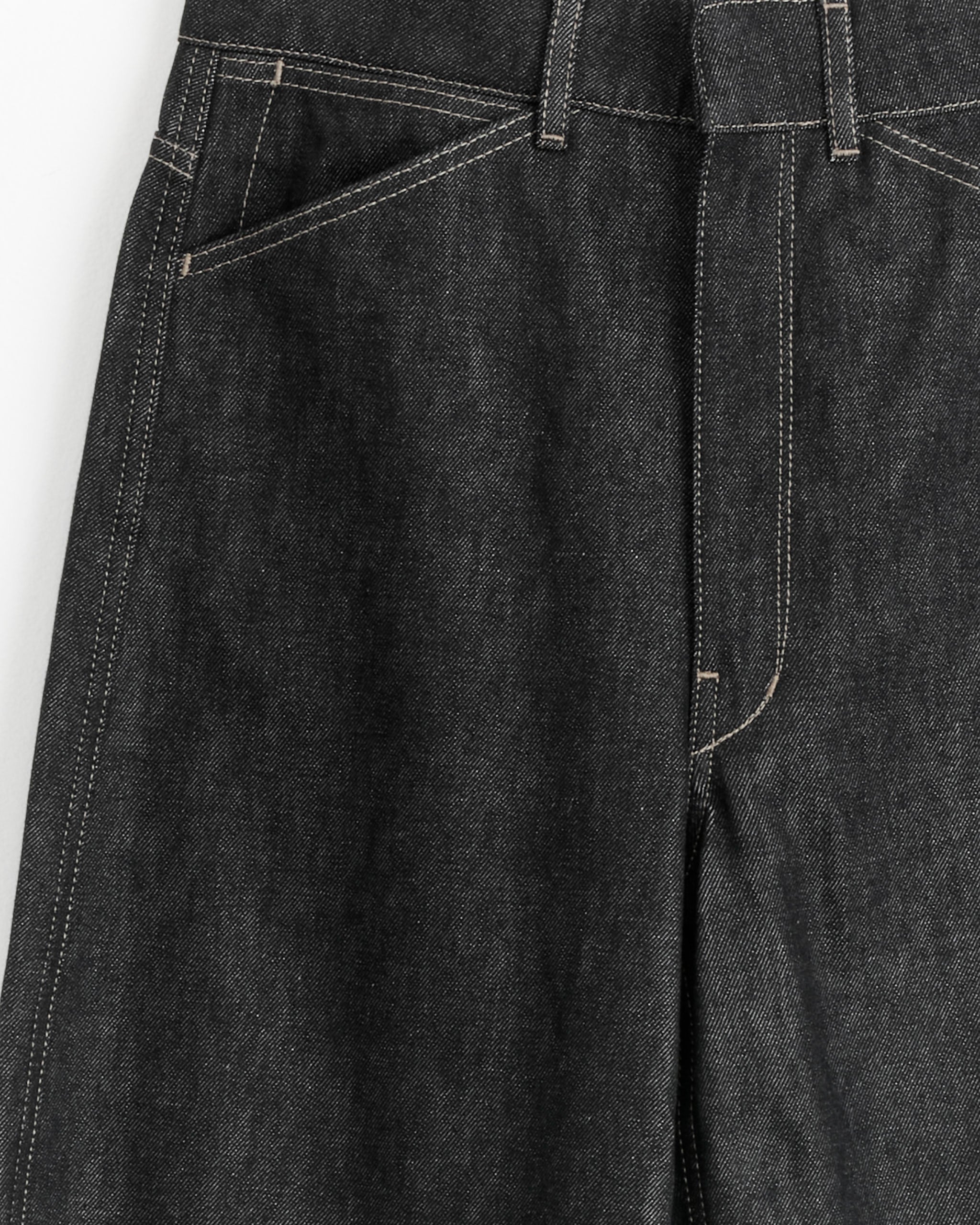 Close-up of the Lemaire High Waisted Curve Pant in Slate, showing visible white stitching, front pockets, belt loops, and part of the fly.