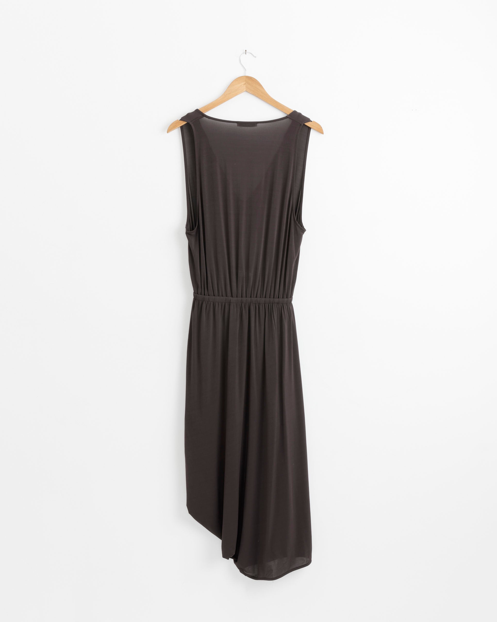 A sleeveless Double Layer Drape Dress in Fig by Lemaire, featuring a V-neckline and asymmetrical silhouette, is displayed on a wooden hanger against a plain white background.