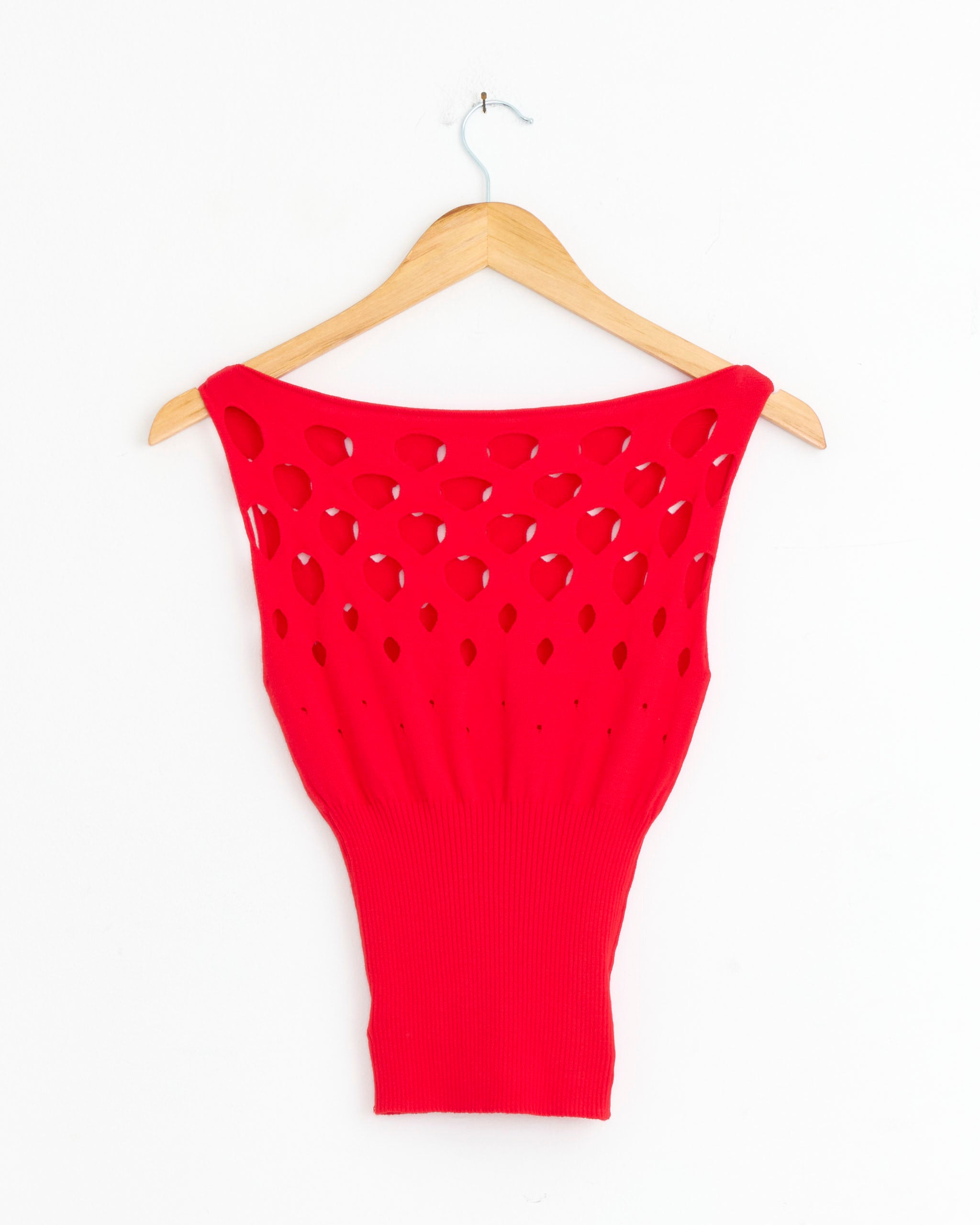 The Gimaguas Discos Top in Red is a bright, sleeveless knit with cut-out circle details, shown on a wooden hanger against a plain white background.
