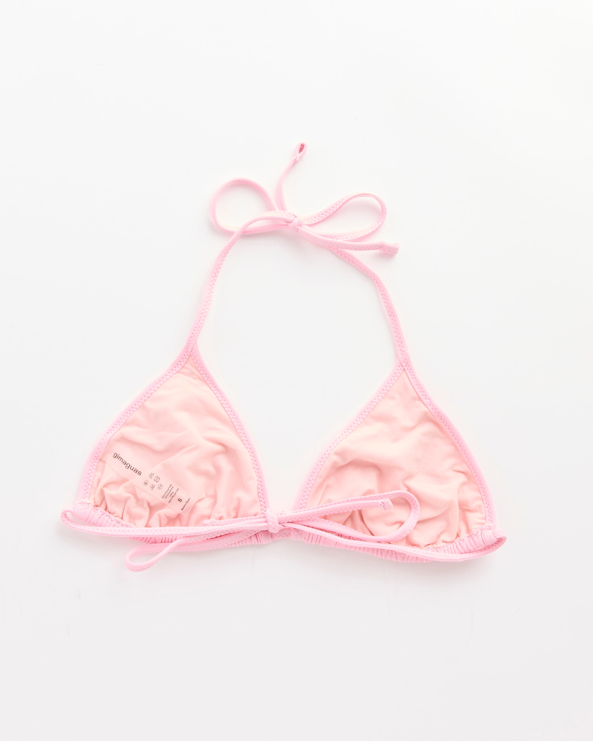 The Bella Bikini Top in Pink by Gimaguas features light pink triangle cups and thin tie straps at the neck and back, shown flat on a white background.